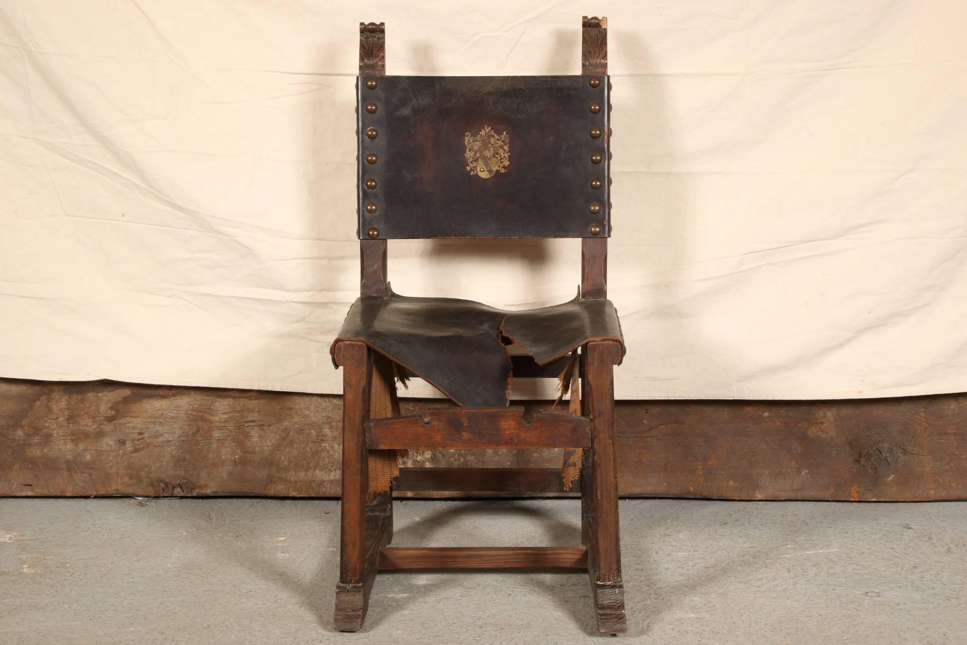 Six side chairs and two armchairs with carved acanthus leaf tops, lower front stretchers, lower H stretchers, and shaped front feet. Black tooled leather backs with gilt crests and nail head attachments. The armchairs with shaped