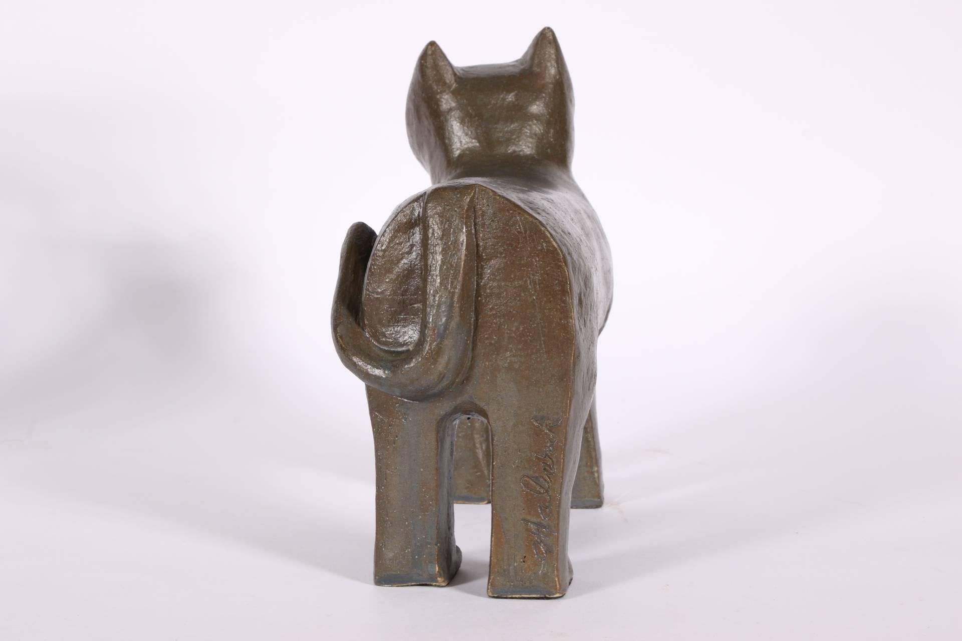Midcentury cat pottery sculpture in a dark gray-green glaze with white eyes. Signed on one back leg.
Condition: small touched up flake to the right side of the face.