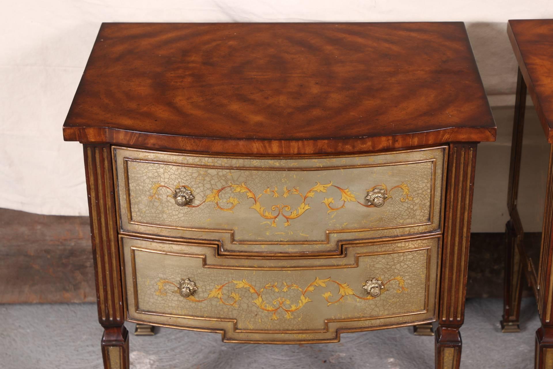 With shaped burl wood tops, two drawers with eglomise style scroll decorated fronts and the shaped sides with urns and scrolls. The reeded frame with gilt details and the square tapering legs with eglomise style details. 
Condition: some scratches