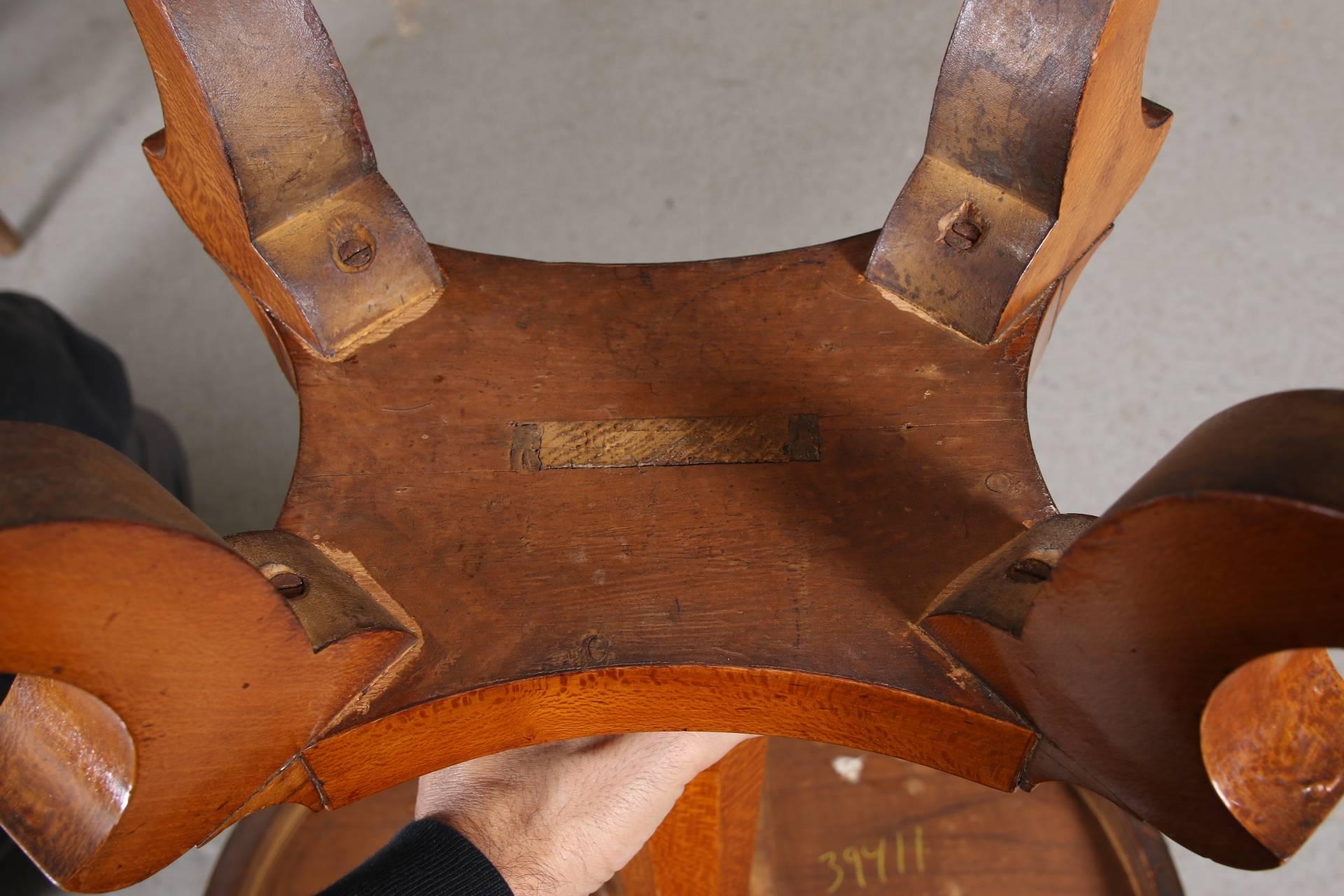 Hairwood or sycamore oval table with a cross-banded overhanging top, raised on a faceted octagonal support. the whole mounted on a shaped base with four angular splayed legs, ending in brass lion's paw caps.