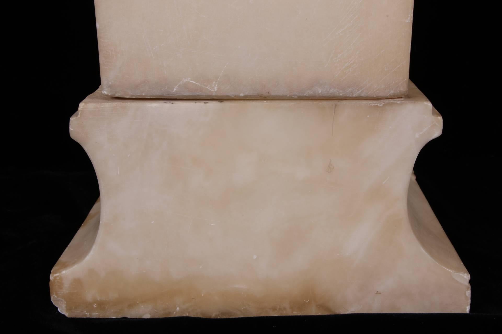 La tímida doncella semidesnuda, con el pelo recogido en tirabuzones con adornos de rosetas, va vestida con un taparrabos con alas en relieve y cadenas. Está envuelta en un largo manto que extiende hacia un lado con el brazo derecho, como si lo