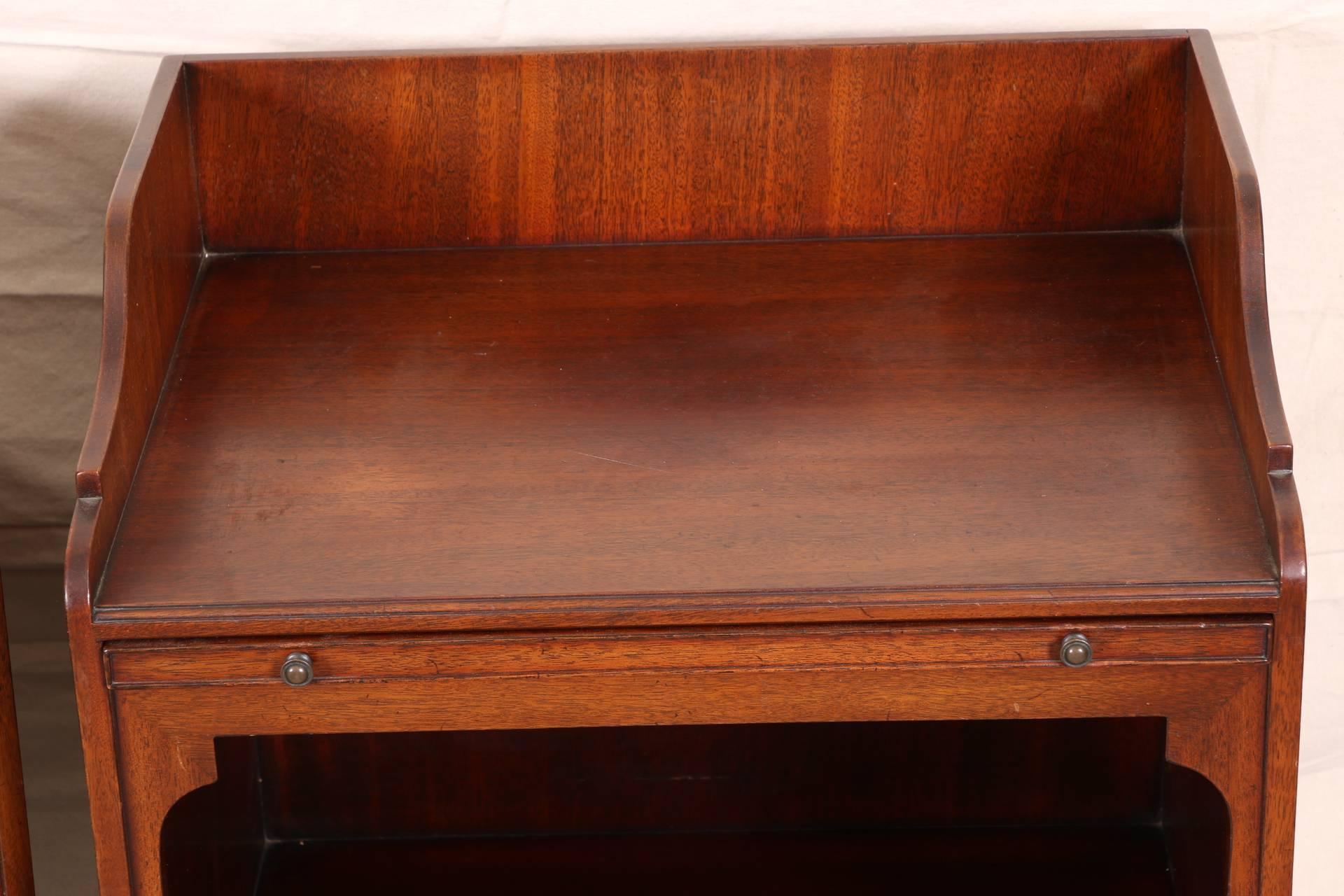 From the 'Beacon Hill Collection,' with 3/4 gallery tops, slide pull with tooled leather top, and large open fronts over a singe drawer. Raised on turned cylindrical legs on casters. Brass knob pulls and carry handles. 
Condition: some wear to the