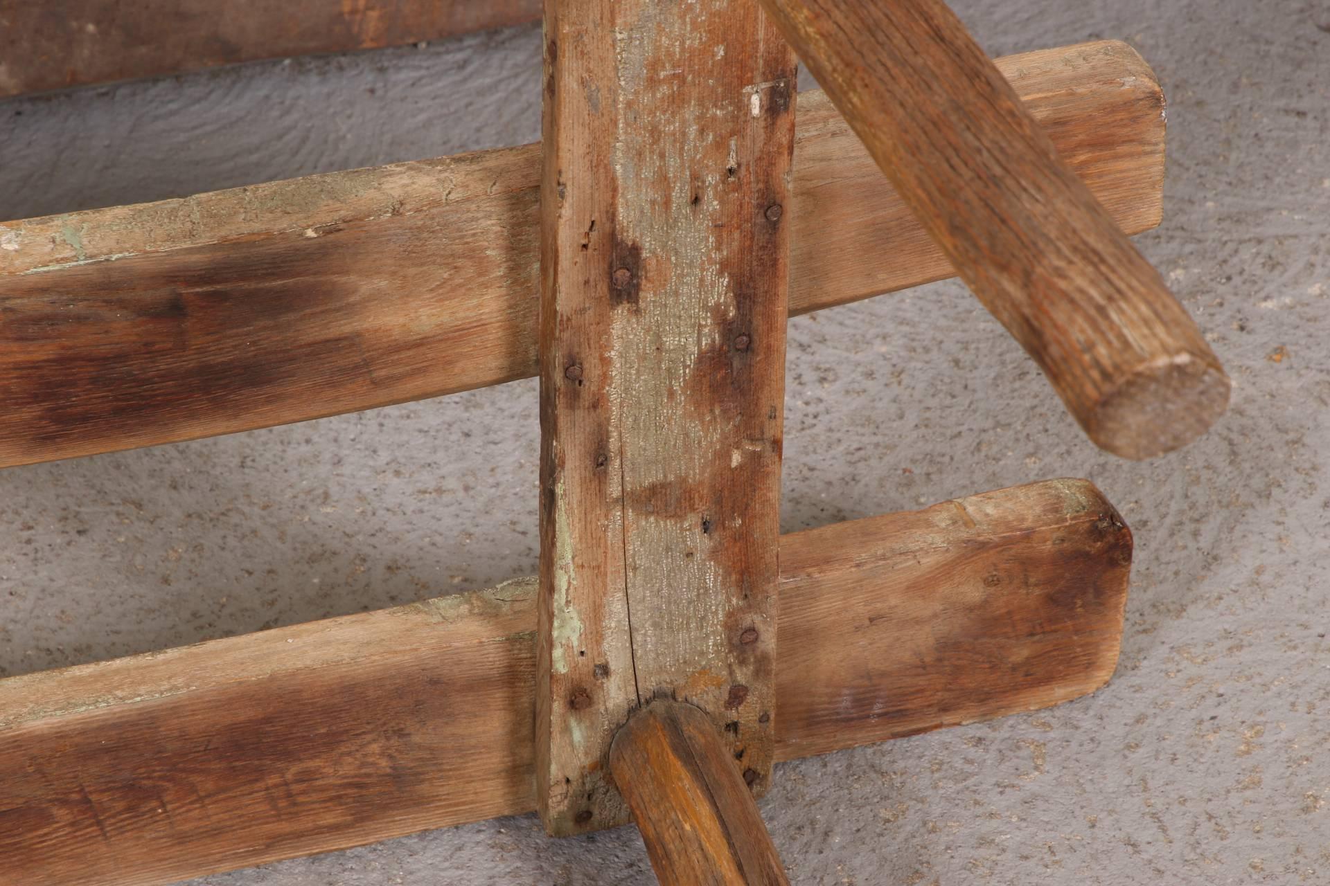 With rough cut cylindrical legs and some traces of old green paint on the top planks. Authentic form with excellent old worn patina.
Condition: worn overall, some warping to the top planks.