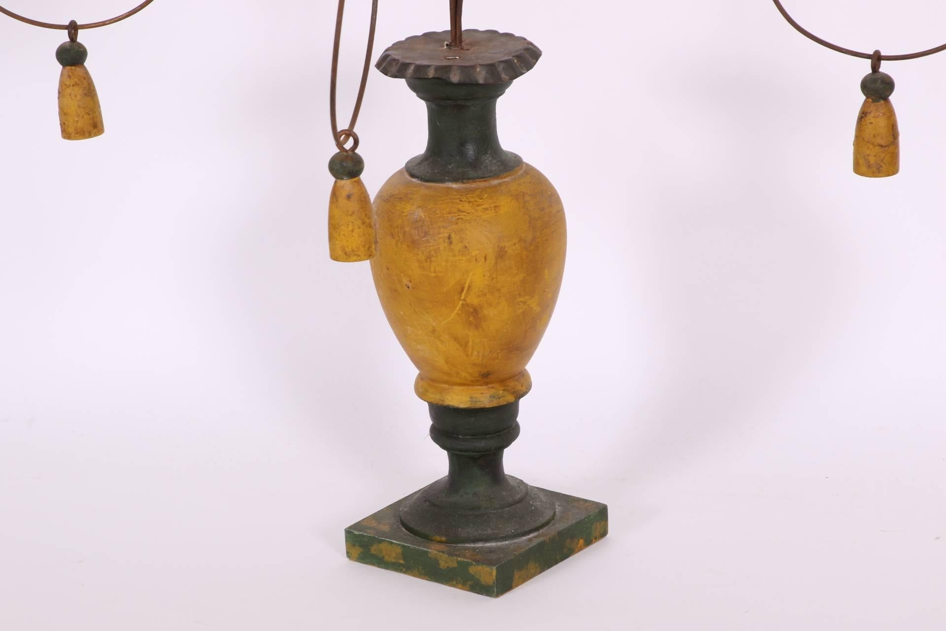 Four-light, with urn form supports in old green and mustard yellow paint on faux marble bases. Three scrolled iron wire arms and one vertical one with green and yellow ‘candles’ and ruffled iron bobeches. Painted tassel form pendants on each arm. In