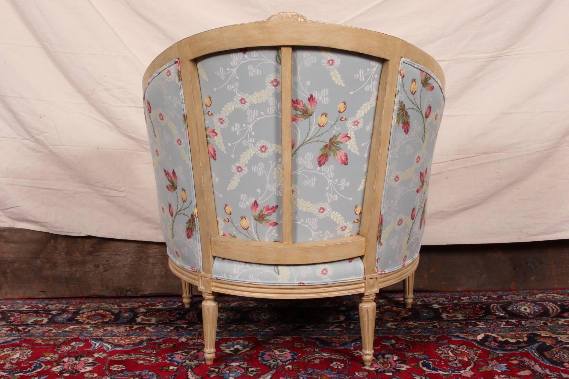 Louis XVI style with carved acanthus crests, scrolled arms, and reeded tapering legs. Upholstered in a pale blue fabric with pink, white, and yellow over embroidered floral sprays. Along with toss pillows. 

 