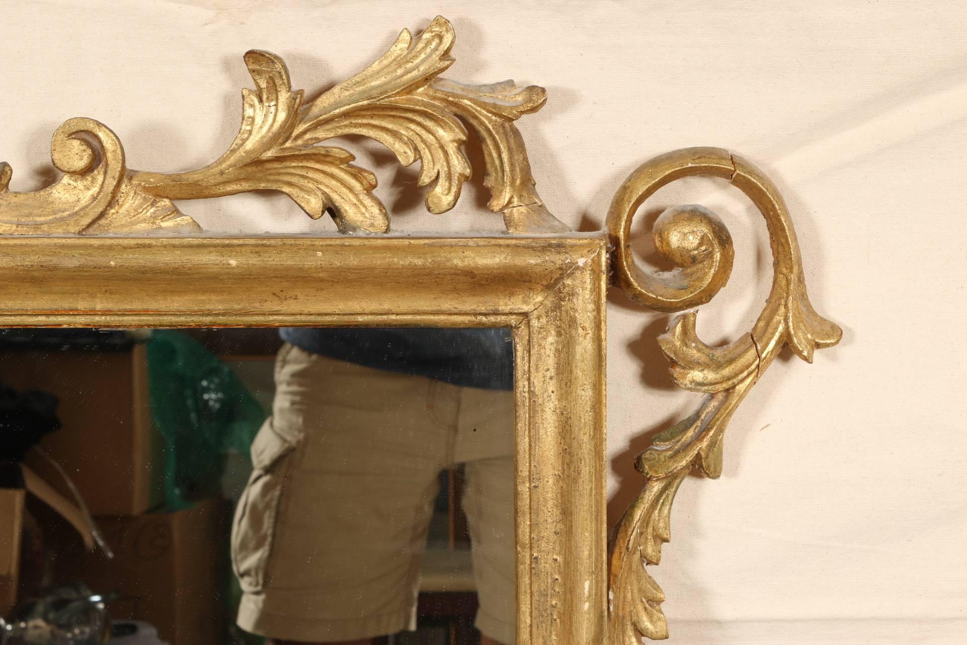 The surround with elaborate openwork acanthus scrolls, a leafy urn finial, and leafy terminal. The slight darkening to the gilt in places makes for a fine vintage finish. 
Condition: chip to top center right leaf point, chip to top left acanthus