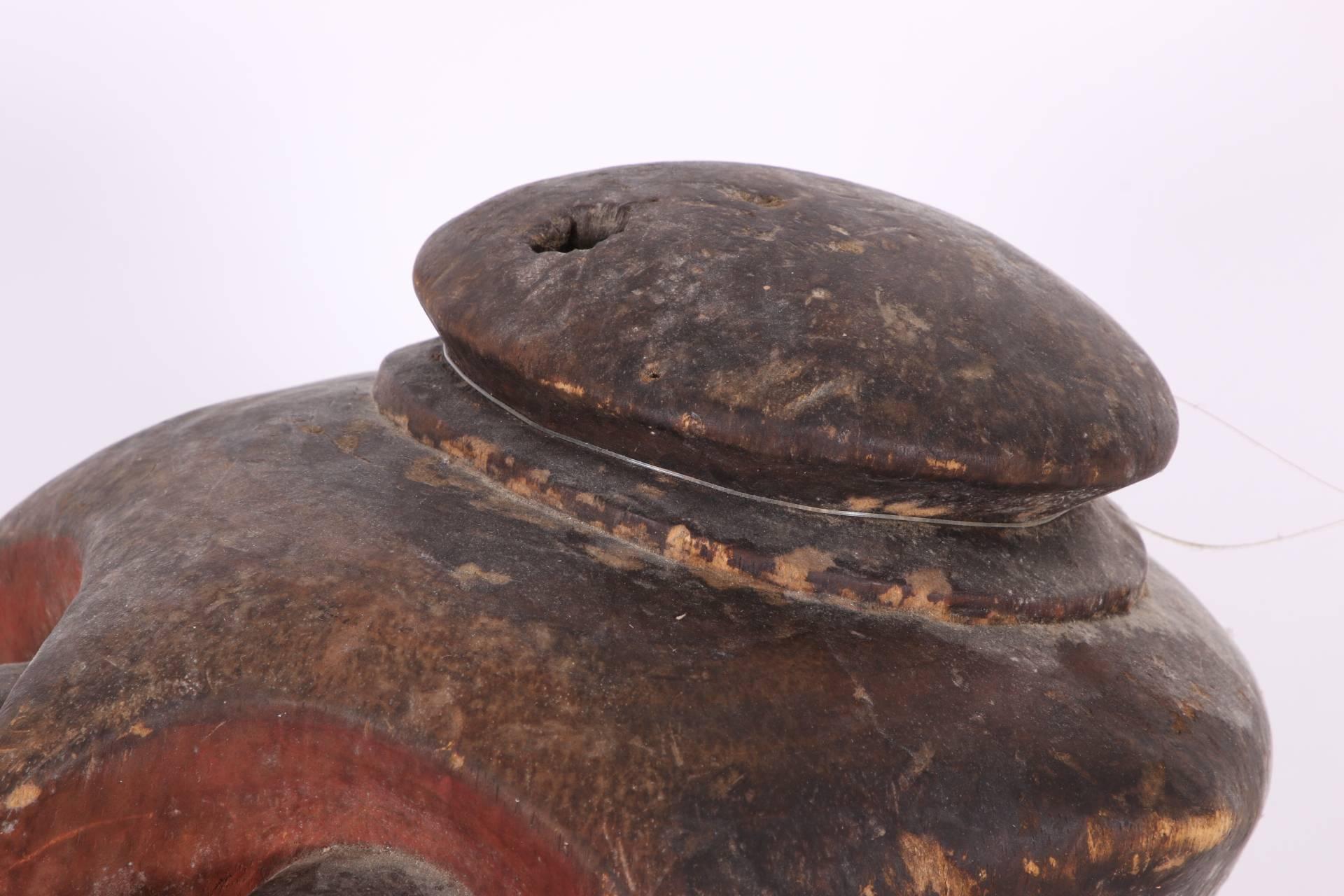 A Beba Bomba, Zaire dance mask worn an s a helmet. A fine example of its type in carved and painted wood in red and black with a triangle patterned beard and heavy carved protruding facial features and ears. Holes below the eyes, at the ears and on