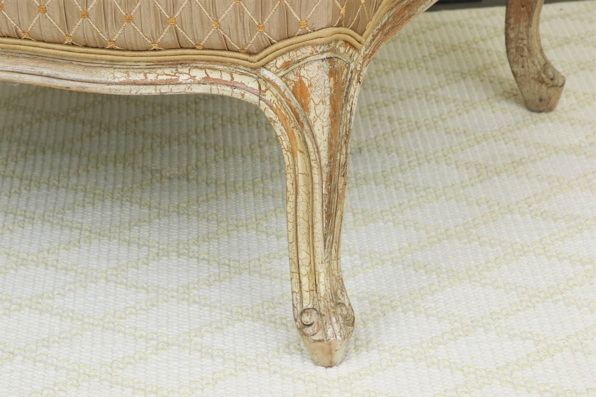Louis XV style In cream distressed paint and scrolled arms and feet. Upholstered in a taupe diamond pattern. Along with tan toss pillows. 