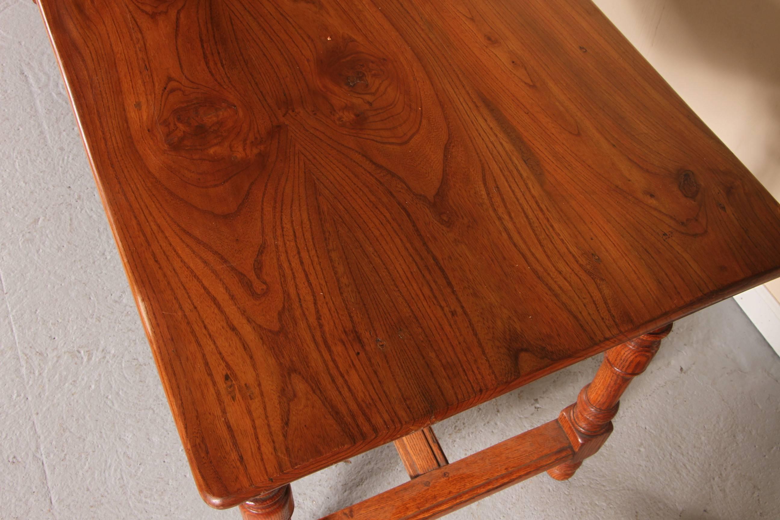 With fine form, elmwood top, oak base with turned legs and stretcher and one work drawer. In very good overall condition.