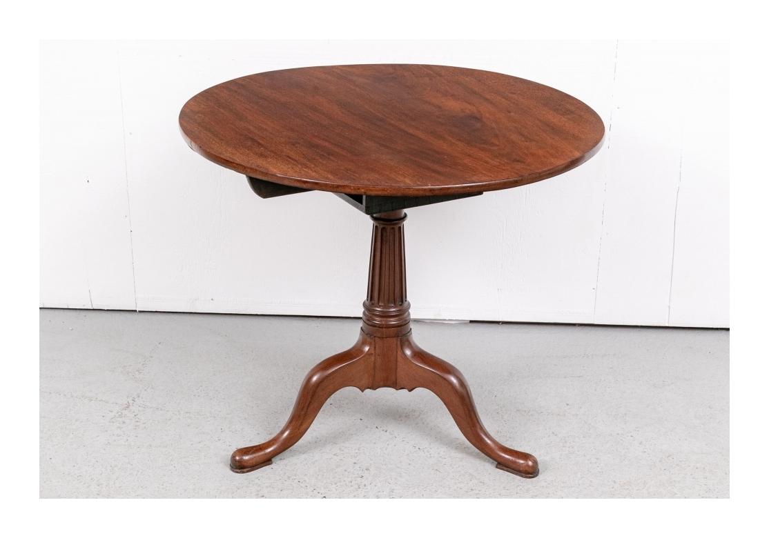 A fine American table in traditional form. It does not tilt as in the original construction. The round top mounted on a fluted tapering columnar support on tripod legs. 

Diam. 34 1/4