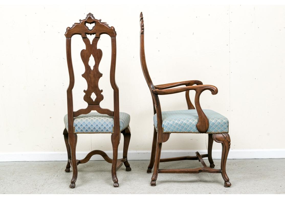 A  set di otto sedie da pranzo di ottima fattura, sinuose e molto decorative. Include due poltrone e sei sedie laterali. Hanno alti schienali intagliati ed elaborate ringhiere ricurve e arcuate con motivi a trifoglio aperto e alte stecche ricurve