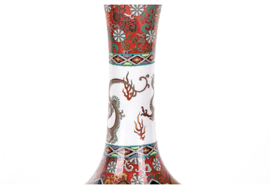 Vintage cloisonné vase mounted as a lamp with dual pull chain operation, mounted on a conforming wooden base. The vase decorated with arched form panels with dragons and exotic birds on glittered ground. The white neck with dragons/serpents and the