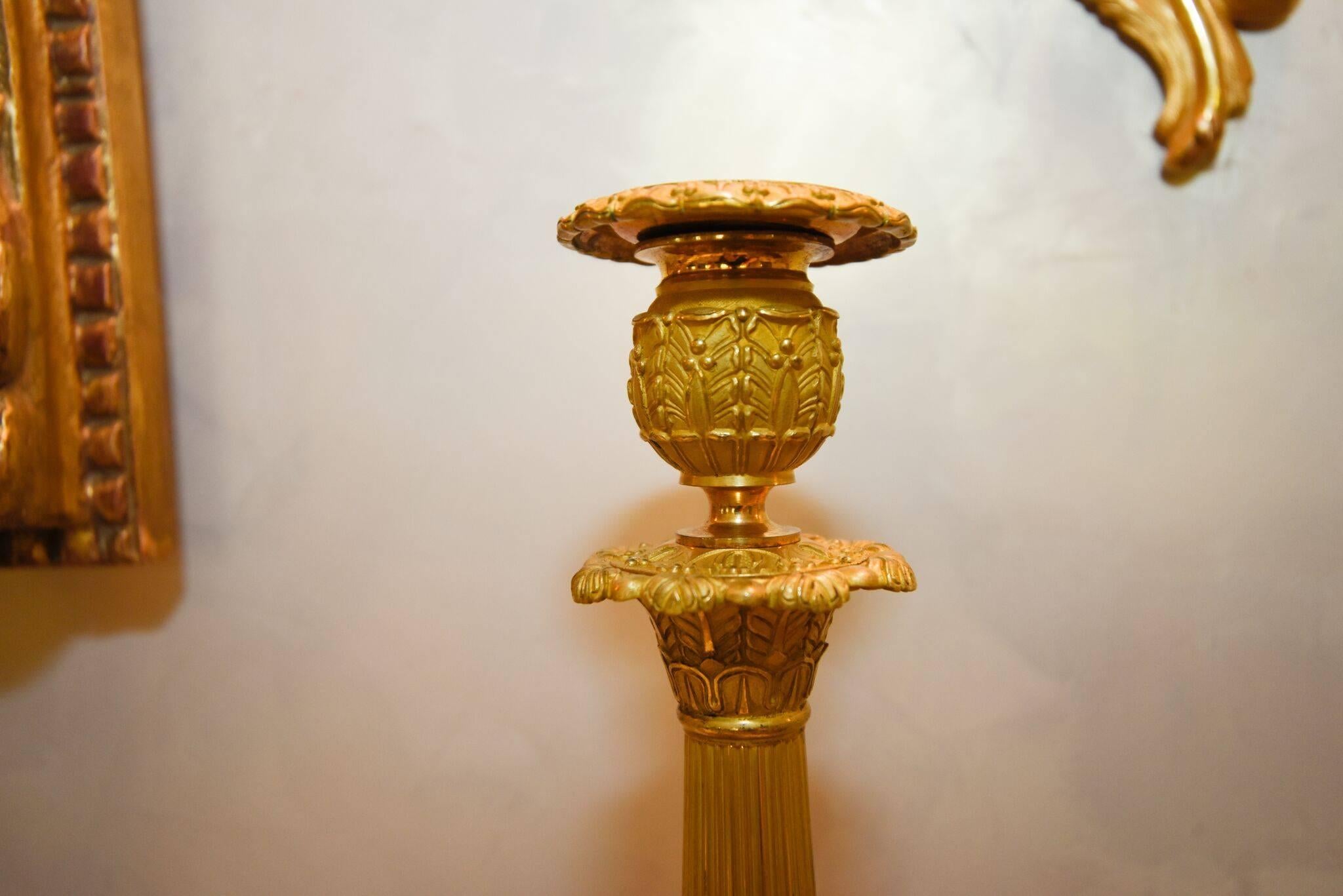 Pairing a neoclassical Silhouette with a gilt finish, 19th century French candlesticks. Top piece comes out to fit a thicker candlestick, circa 1880, Made in France.
