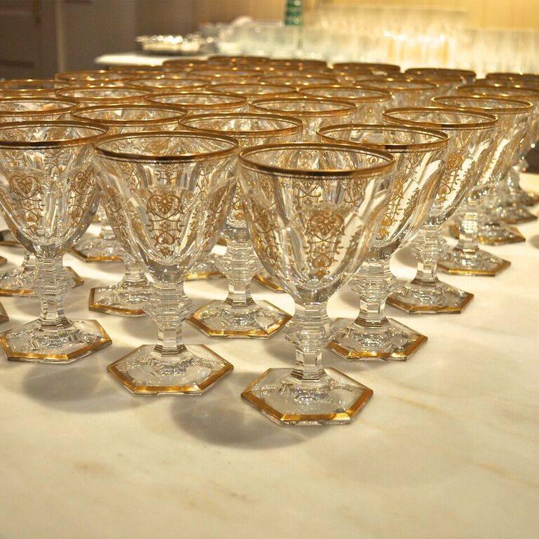 These crystal Baccarat glasses have the discontinued Empire pattern which dates to 1825. The pattern has golden damask accents and yellow gold trim. The set includes 32 water goblets, 32 champagne flutes and 32 wine goblets. Measurements for each