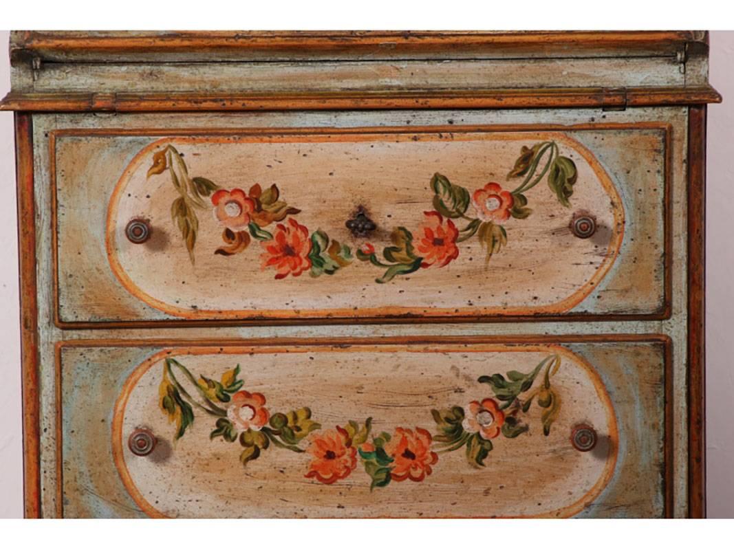 Exceptional diminutive
 antique Italian slant front desk with hand-painted florals and gilt embellishments, raised on bracket feet.
Condition: good, consistent with age. Key included.