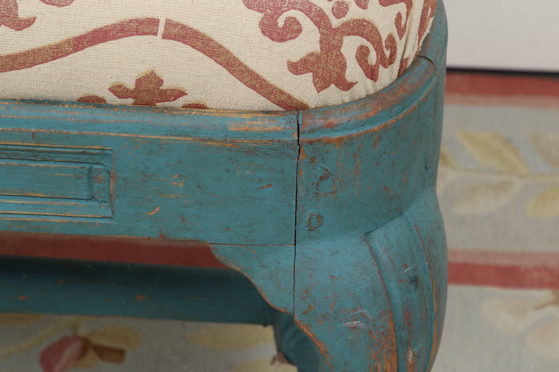In turquoise paint with a triple shaped seat back, the splats with carved foliate crest rails. Lower shaped and carved frame with shell and leaf motifs. Angled sides with shaped arms, cabriole legs in front and splayed ones in back, with a long
