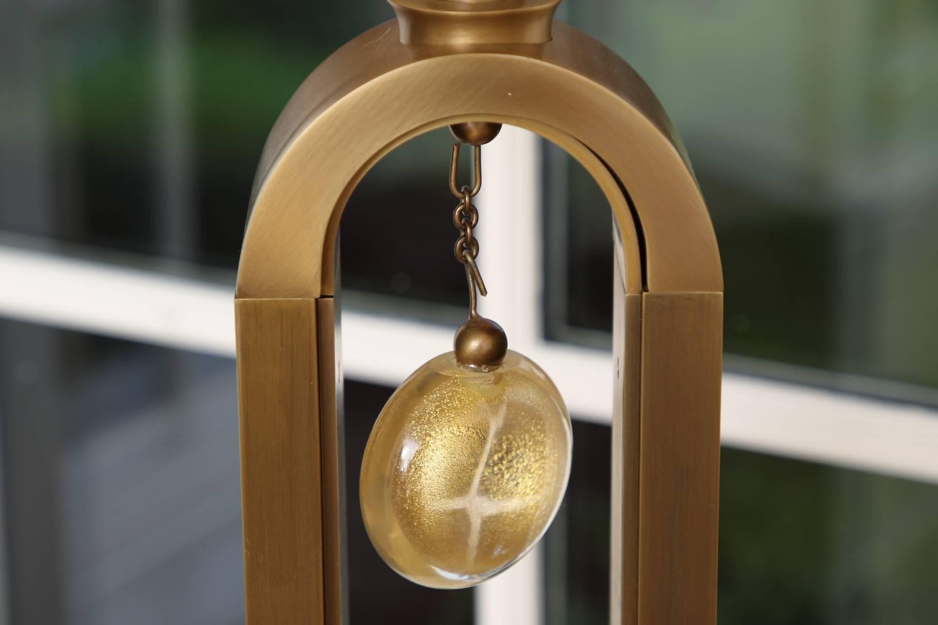 Brass tall arch shaped forms with Murano gilt glass disc pendants and ball finials. Mounted on curved rectangular bases. With oval white fabric shades. Very good condition.
 