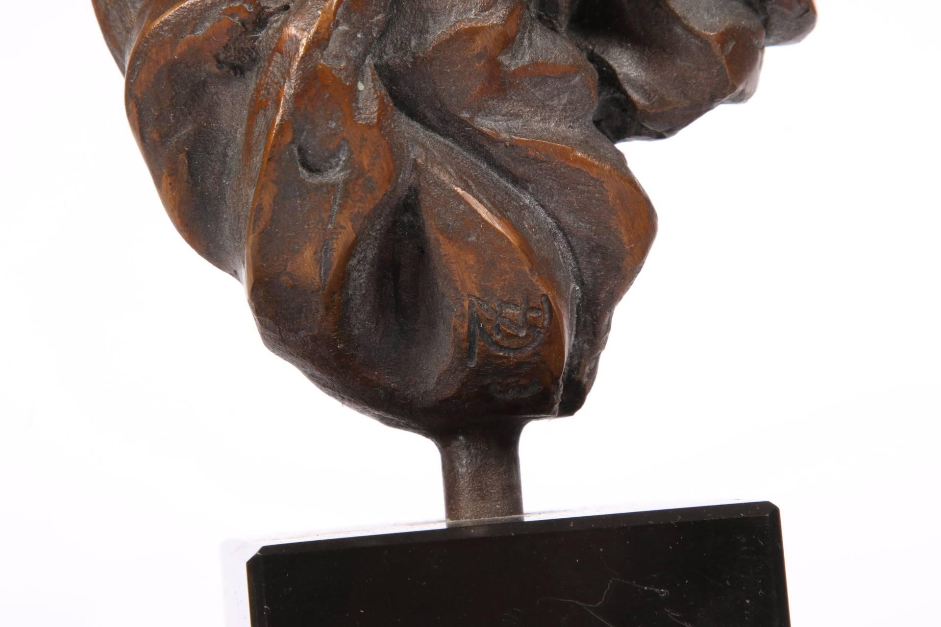 Dark reddish bronze abstract head of a person or an animal. Monogrammed and numbered two near the base. Mounted on a black marble base.
 