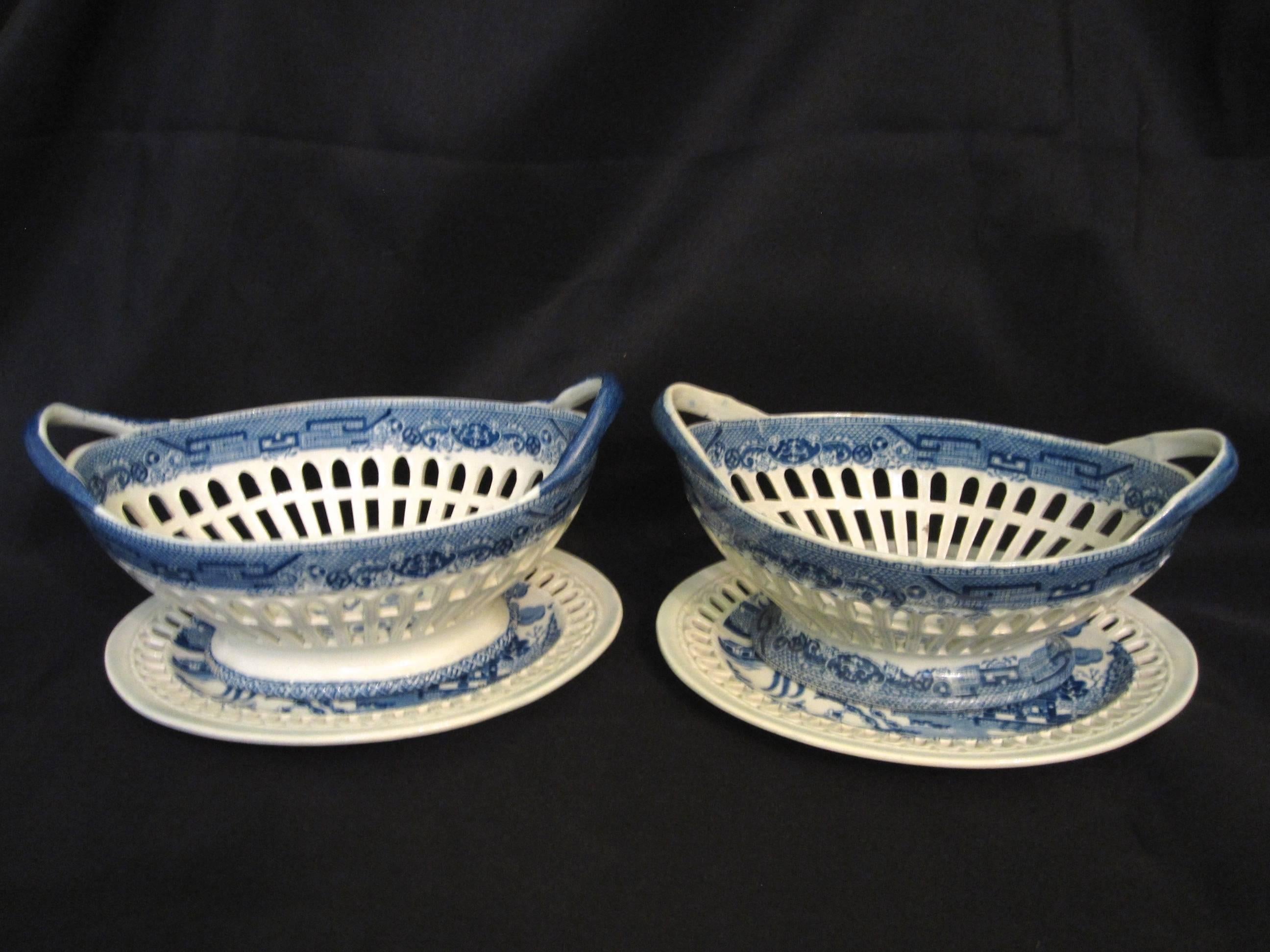 A near pair of English Staffordshire, pearlware chestnut baskets on stands, circa mid-late 1700s. A cobalt blue on white chinoiserie transferware pattern called willow or bird, the handled baskets are pierced, the stands have reticulate rims. The