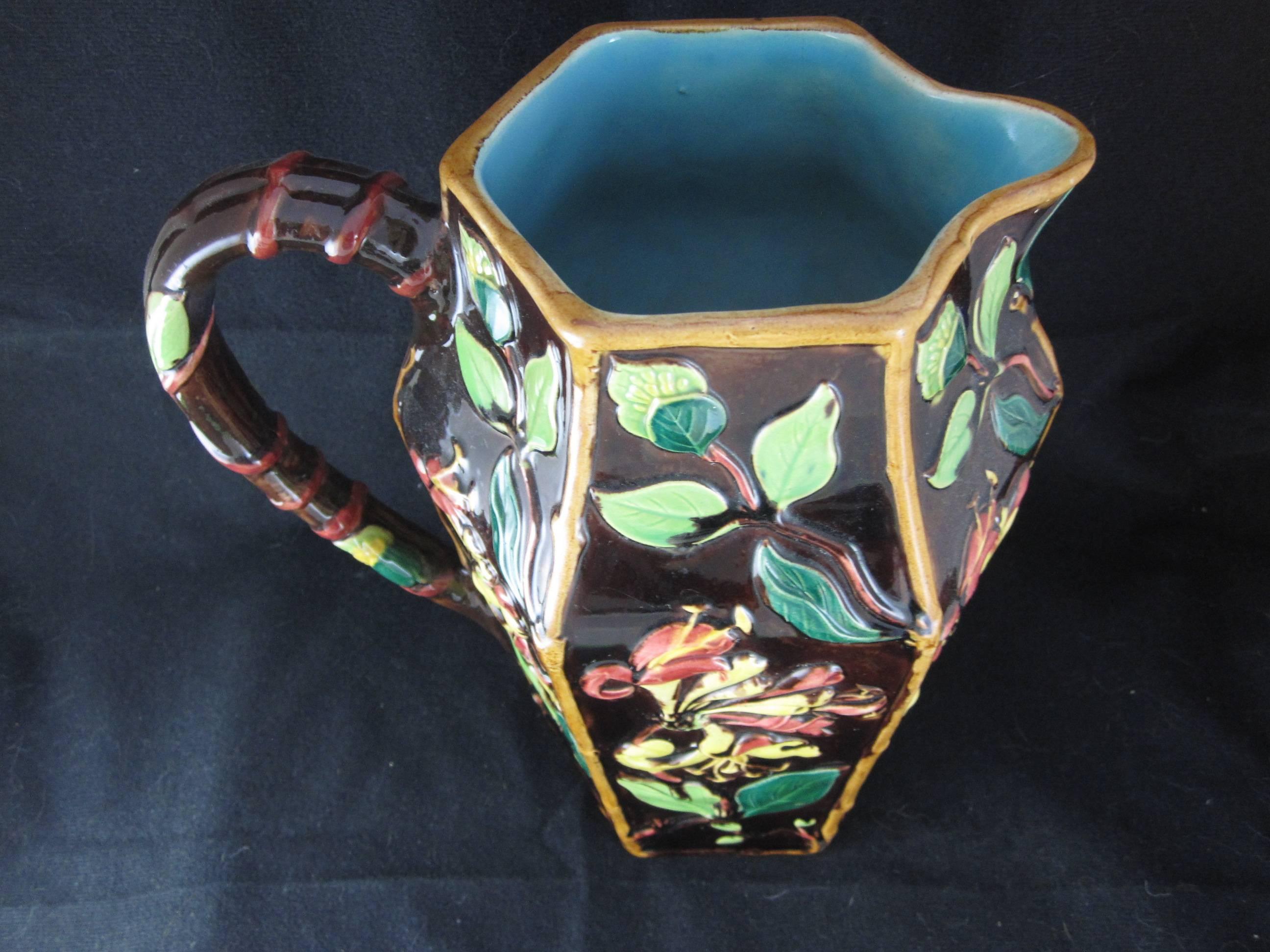 A scarce English Majolica pitcher, attributed to William Brownfield, circa 1860. A large and heavy Aesthetic Movement piece showing aspects of the Honeysuckle vine. The flowers are glazed in yellow and deep pink with leaves in varying shades of