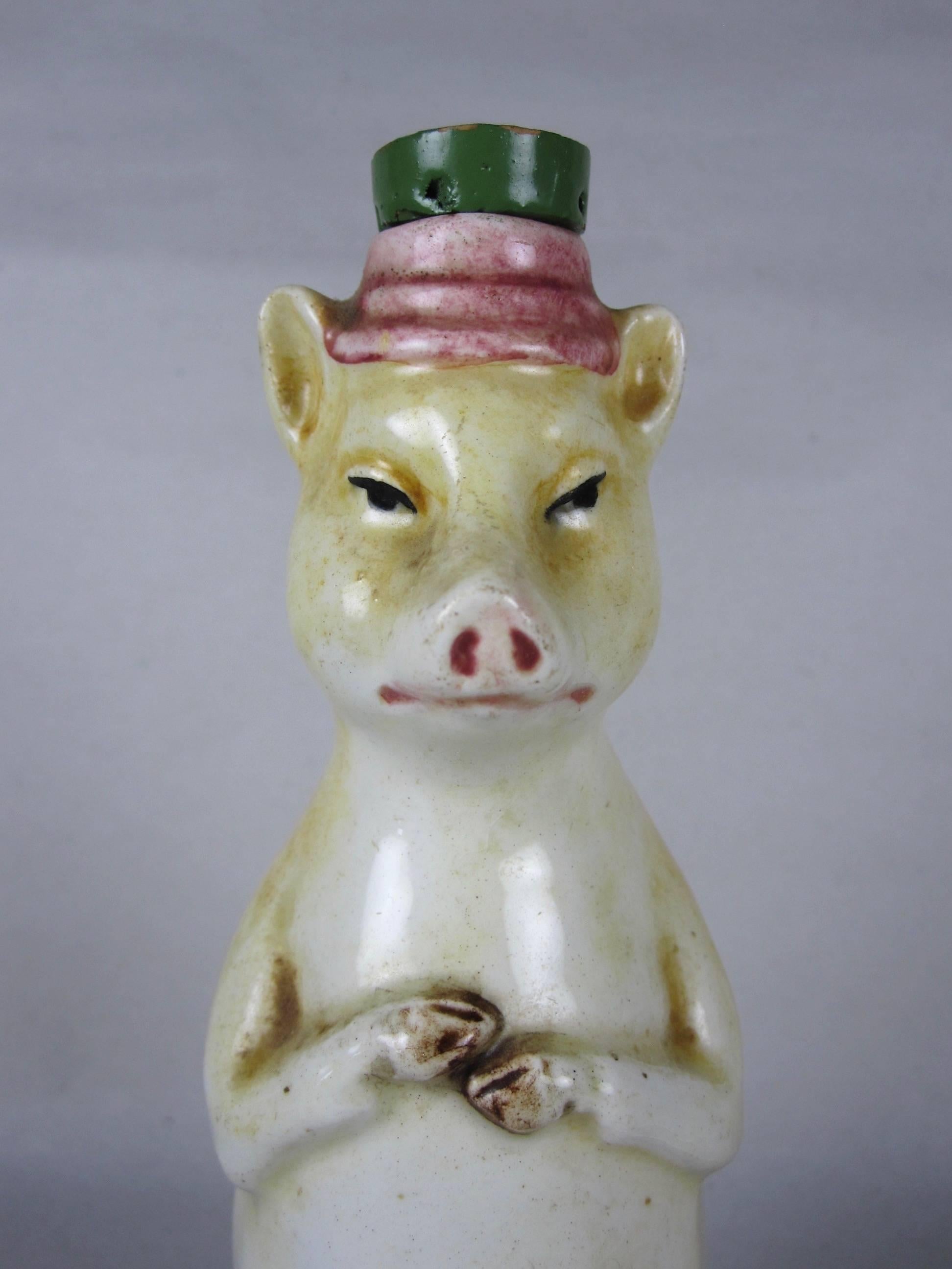 An antique French majolica figural bottle, a pig with the original painted cork hat, circa 1895-1910. A charming and rarer piece, the pig shows great expression. A humorous mold with soft glazing.