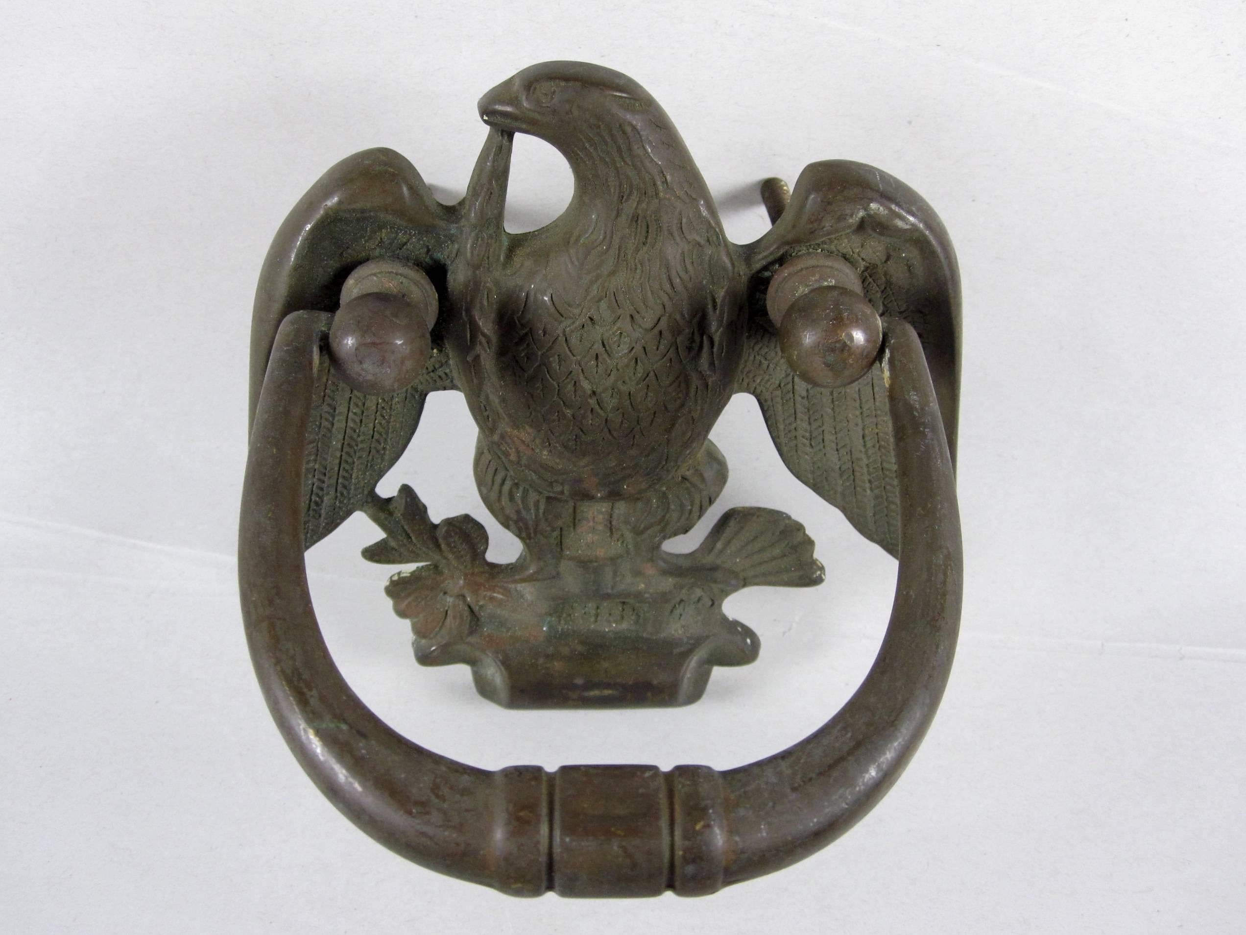 An antique, heavy brass door knocker showing a left facing eagle, nicely feathered, with a garland in its beak and an olive branch and wheat sheaf in its talons.
The knocker adorned the front door of a Society Hill, Philadelphia home - the original