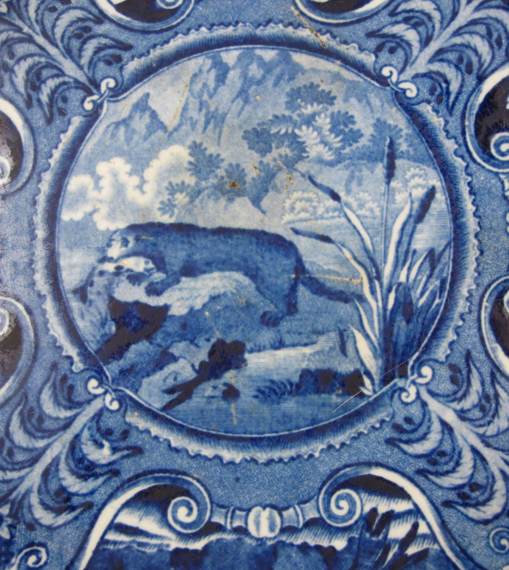 An earthenware plate transfer printed in blue, the River Otter, part of the desirable  Quadruped series, John Hall & Sons, Burslem Staffordshire, circa 1825-1830.

 The animals in the border cartouches are clockwise from the top: Hedge Hog and