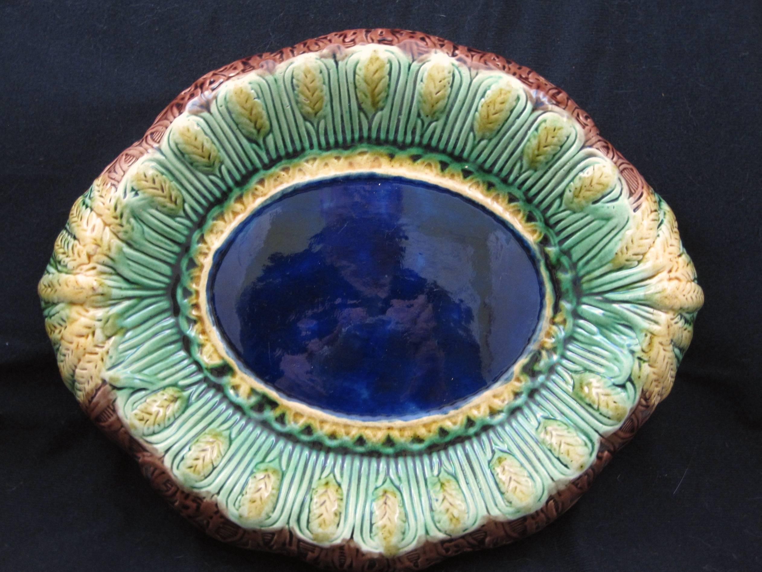 An English Majolica wheat motif bread tray in the Renaissance Revival style, circa 1880-1885. 

A heavy and dimensional platter showing a running border of wheat heads encircling a deep cobalt blue center ringed with a basket weave. Gathered wheat