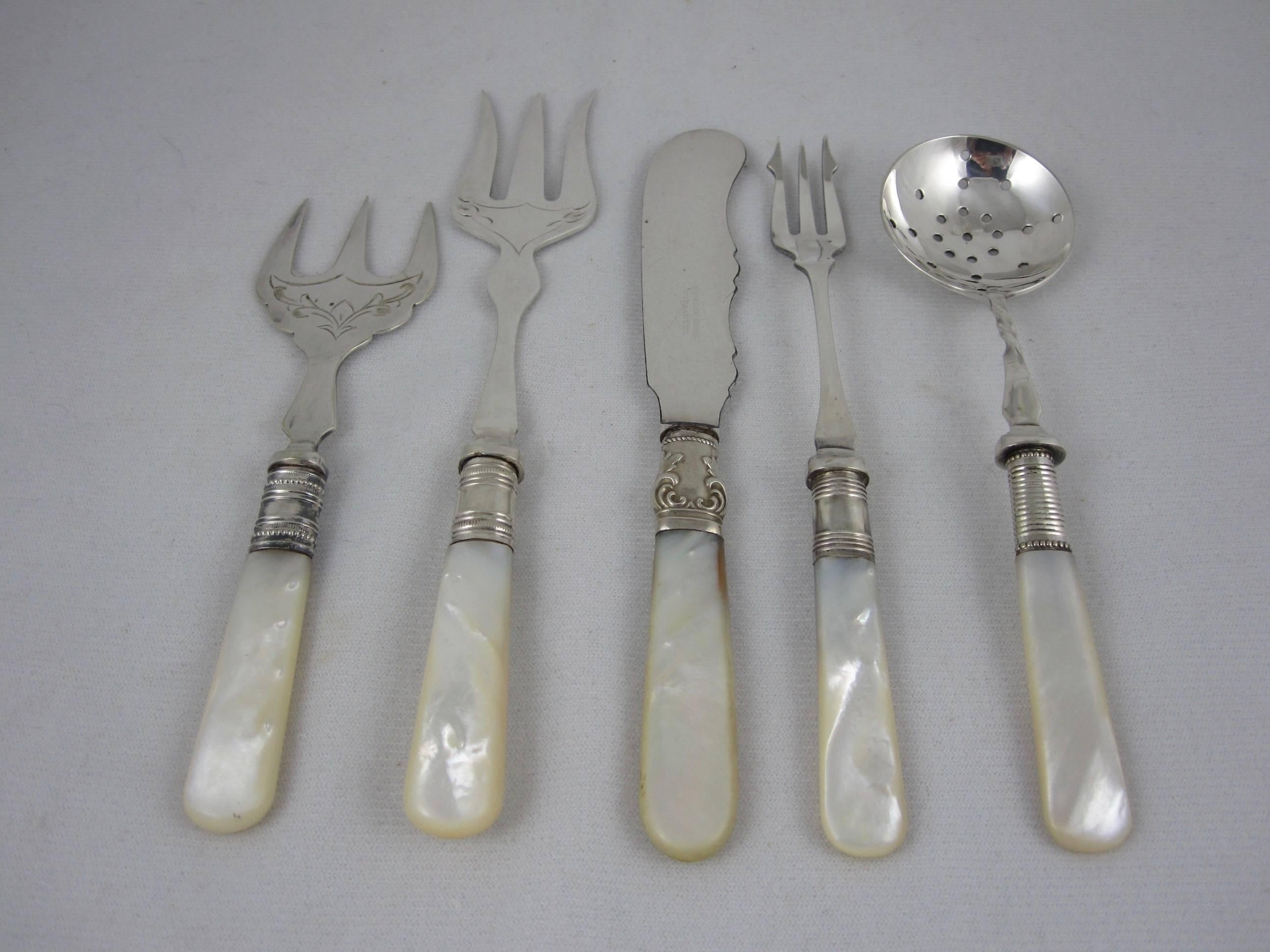 An assortment of English mother-of-pearl handled, sterling silver and silver plated servers, circa 1880-1910. Set of five.

One pierced spoon with a twisted stem, marked EPNS, 6″ L x 1.5″ W x .50″ H.
One spreader, sterling silver collar, blade