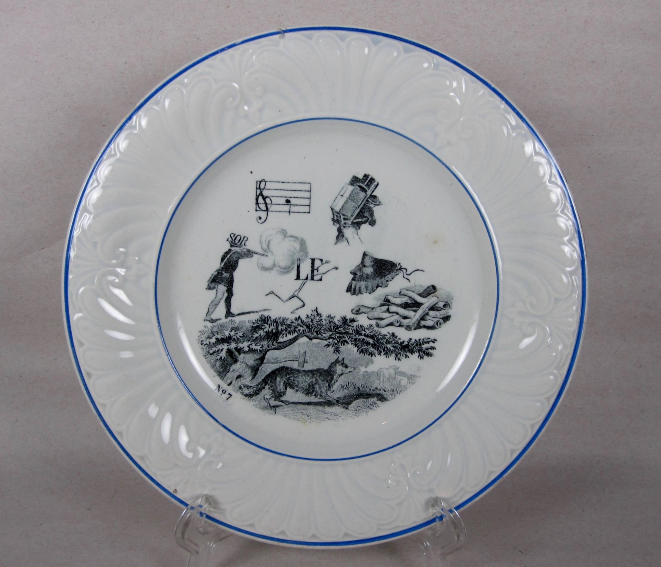 A set of six French rebus puzzle dessert plates, transfer printed in black on a white earthenware body. When solved, the picture puzzle spells out a wise saying or maxim, 19th century.

From the early 1800s-early 1900s, most French homes had a set