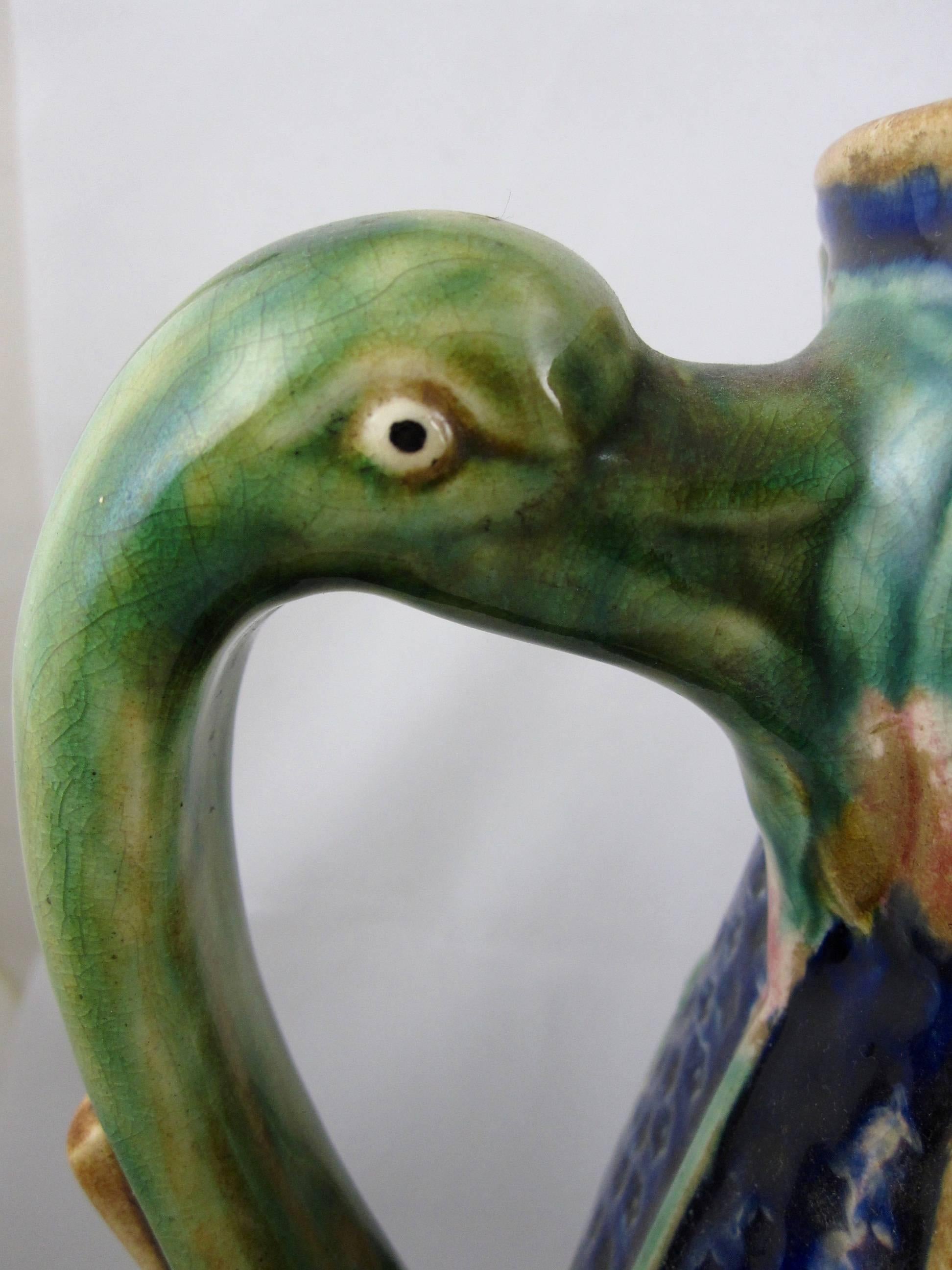 A monumental English or perhaps Scottish Majolica ewer or oversize jug, showing a stork and a crane wading in a marsh or pond with cattails and bulrushes. The handle is made of the long neck and head of a crane. The cobalt blue ground is pocked with