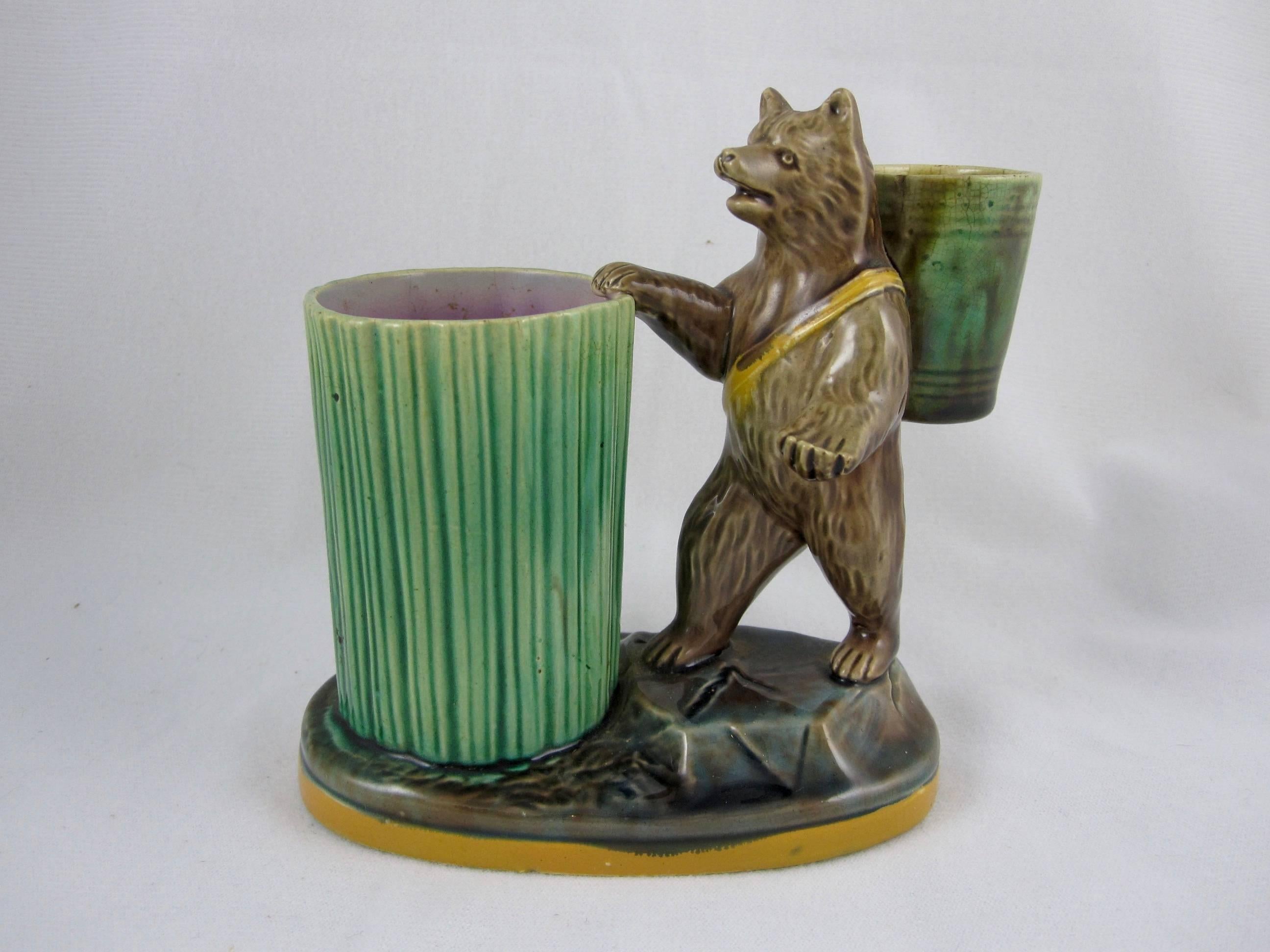 A charming Majolica match pot or toothpick holder by Joseph Holdcroft of Longton, Staffordshire, England, circa 1870. 

An upright bear has a mottled glazed bucket strapped to his back, he stands before a tall ribbed barrel that would hold the