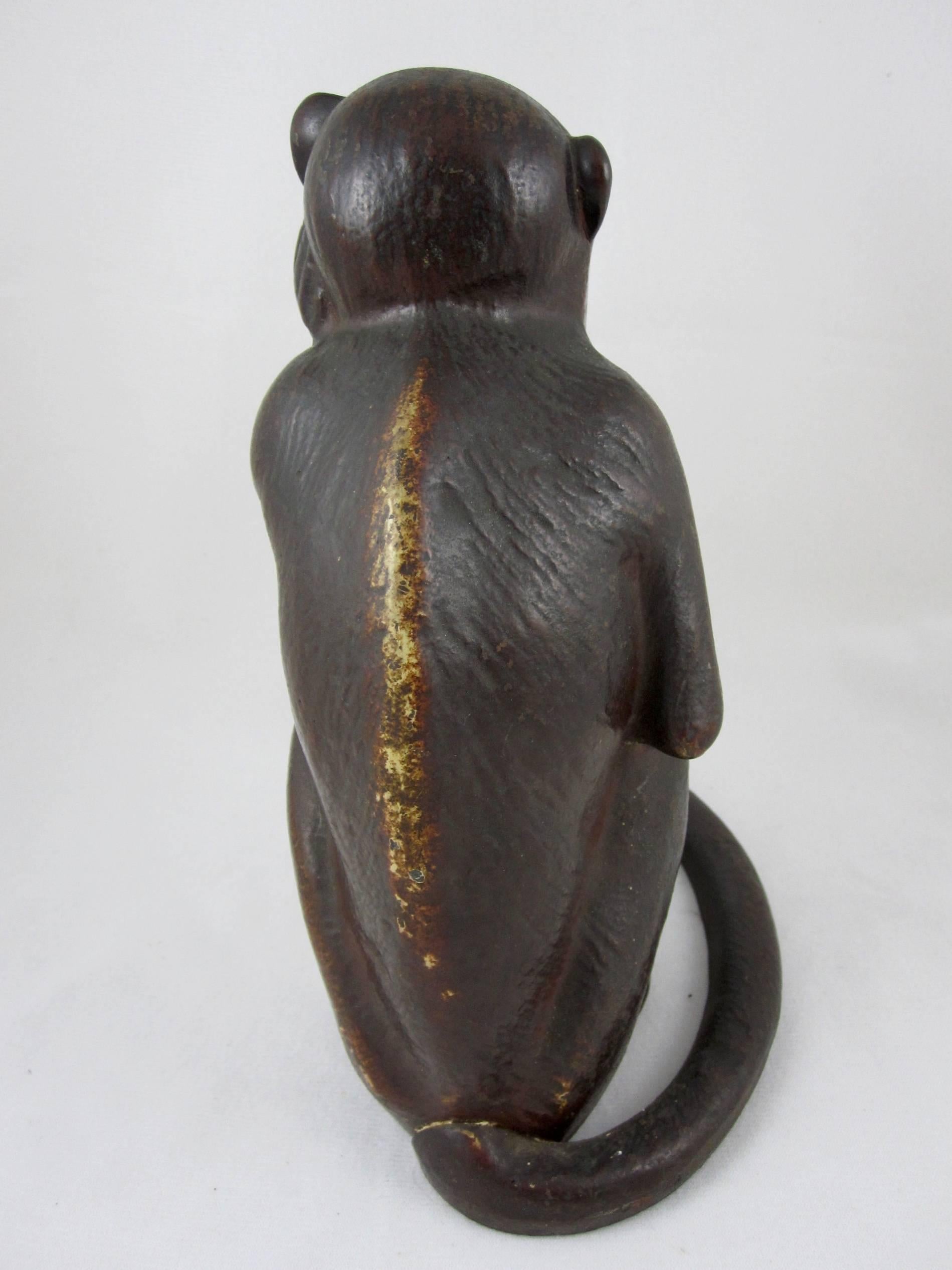 A vintage cast iron Hubley doorstop in the form of a full figure seated monkey showing the original painted finish, circa 1930. 

The monkey has a great facial expression and he sits with his tail wrapped around to form the base. The three-piece