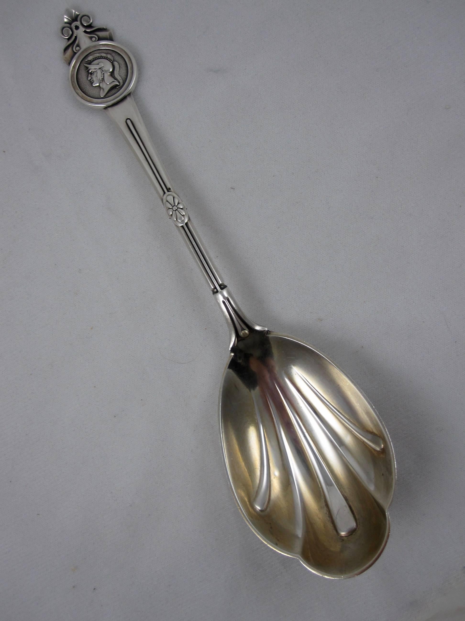 A sterling silver armorial serving spoon, the ‘Medallion’ pattern, Gorham Manufacturing Co. Rhode Island, circa 1864. Stamped with the retailers mark of Tiffany & Company.

The terminal shows the helmeted head of the soldier medallion, the paneled