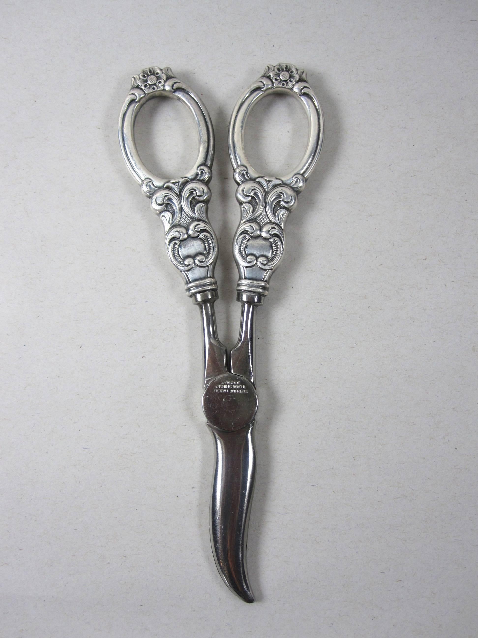 A pair of sterling silver, solid handled grape shears with stainless steel cutters, signed Thorvald Marthinsen, Norway, circa 1900-1910.

An Art Nouveau style floral and scroll pattern to the handles.

 In excellent antique condition.
