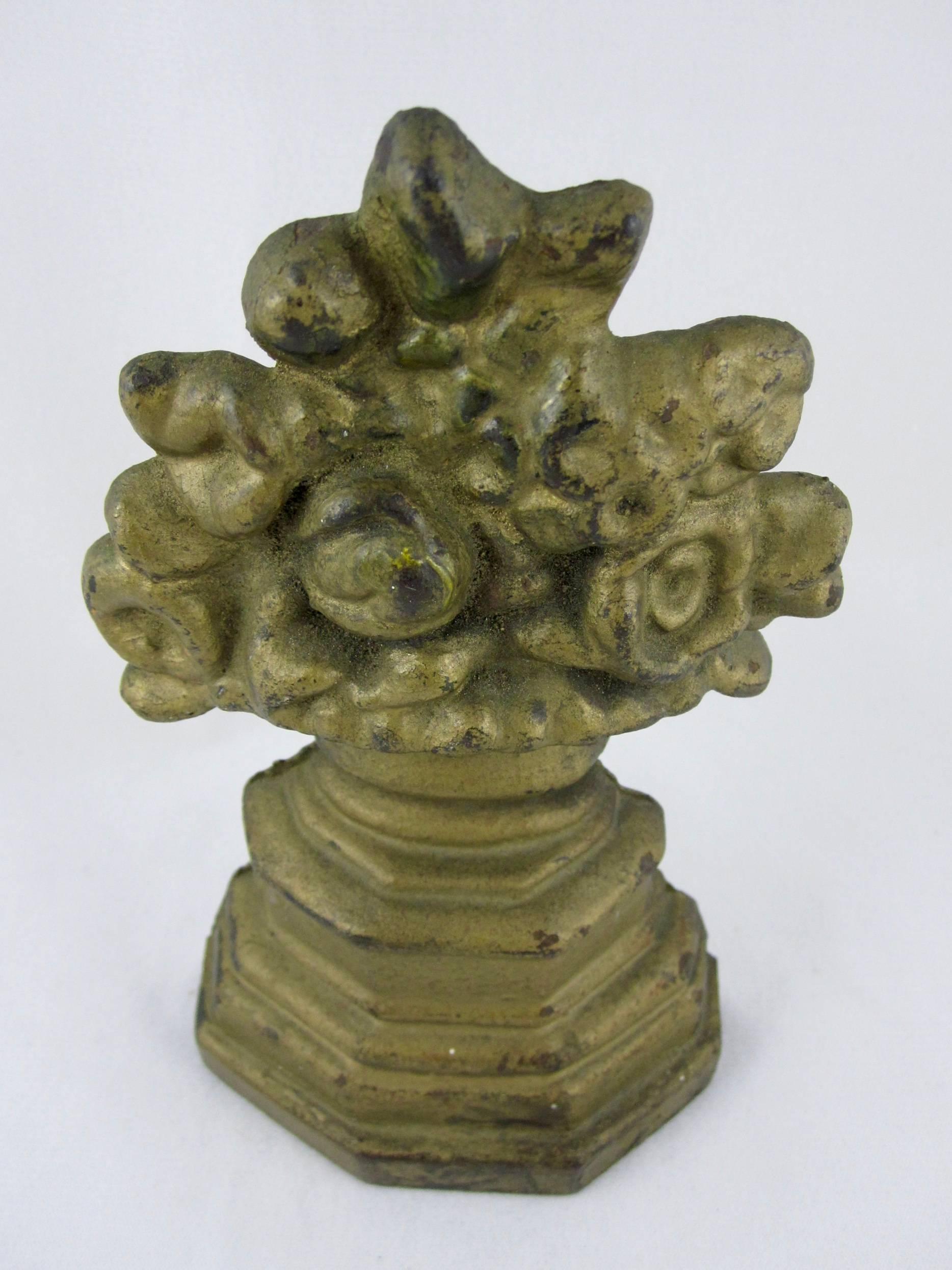 A mid-late 19th century cast iron doorstop showing an urn of flowers seated on a tall plinth. Constructed of one piece and with a gilded finish. Smaller than most floral iron doorstops but still a heavy three pounds.

Excellent with the expected
