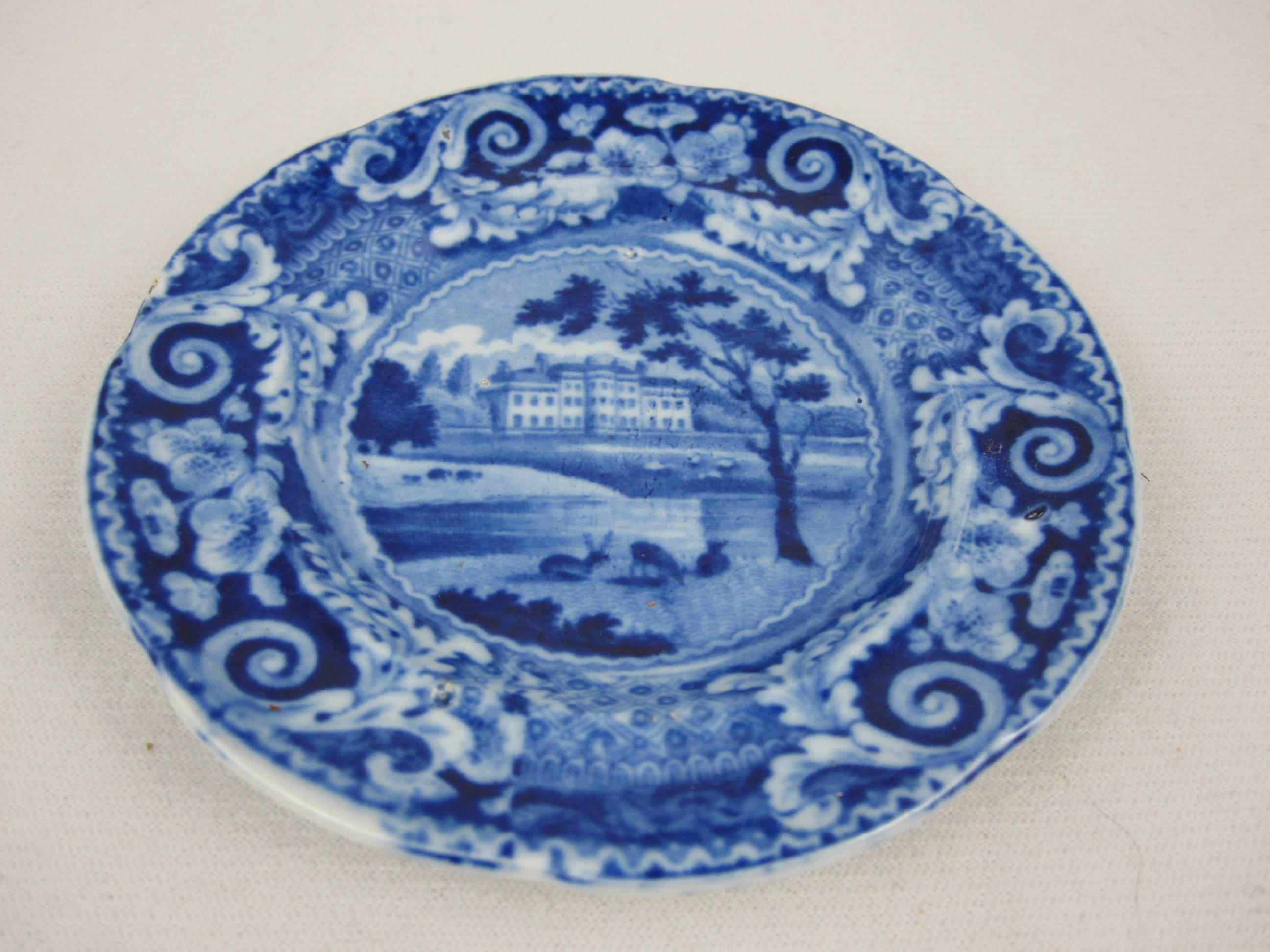 An historical blue and white transfer printed pearlware cup plate, a view of Denton Park, Yorkshire, with the large scroll border. Grazing deer are in the foreground, the estate is seen in the distance. A wide scroll and floral border.

Made by