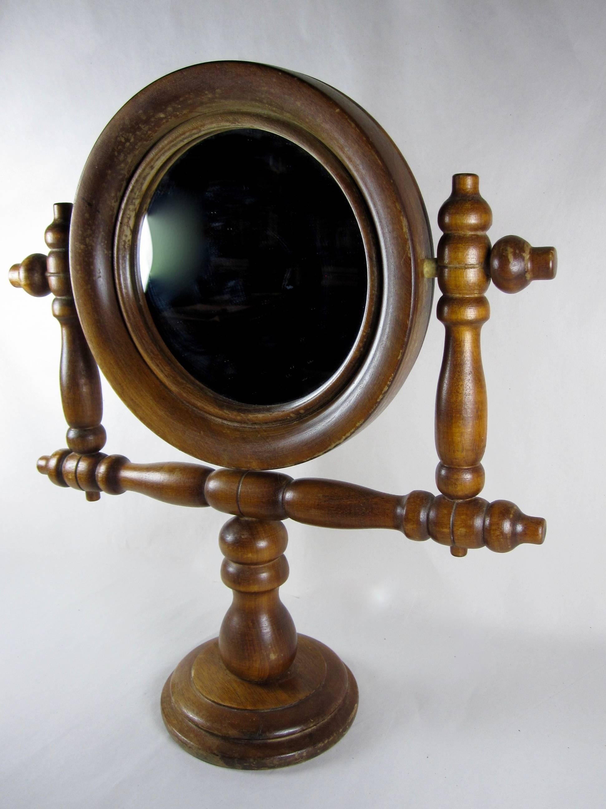 Found in France, a gentleman’s Salon de Coiffure shaving mirror on a turned wooden stand, from the Napoleon III era.

The adjustable mirror is set in a round wooden bezeled frame, the stand is made with turned wood arms. The mirror swivels fully.