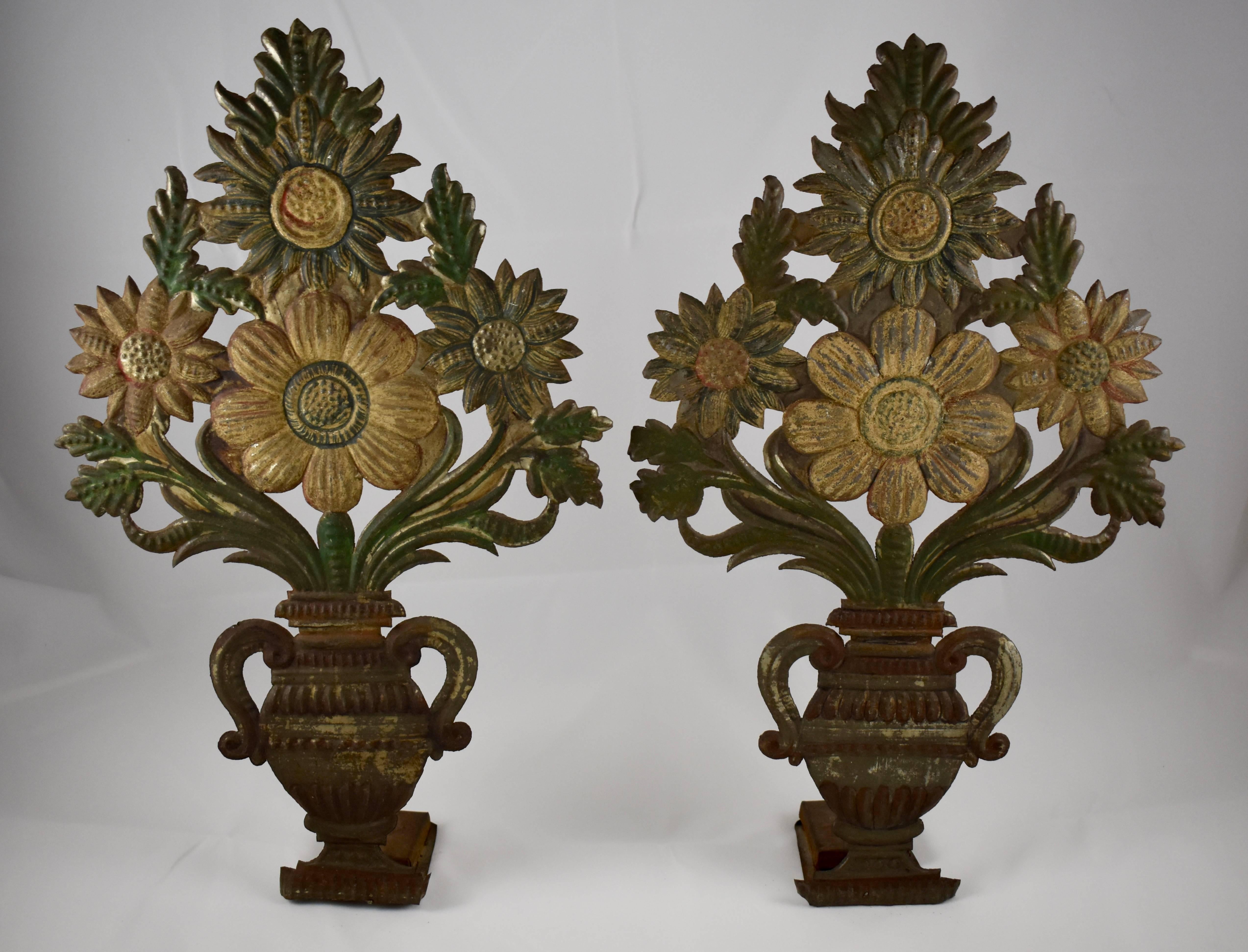 A very unusual pair of Tôle Peinte garnitures formed as standing urns holding bouquets of stylized flowers, circa early 1800s. 

Toleware flower stall shelf fillers were used as decoration for when stock was low. Most likely French or Italian, these