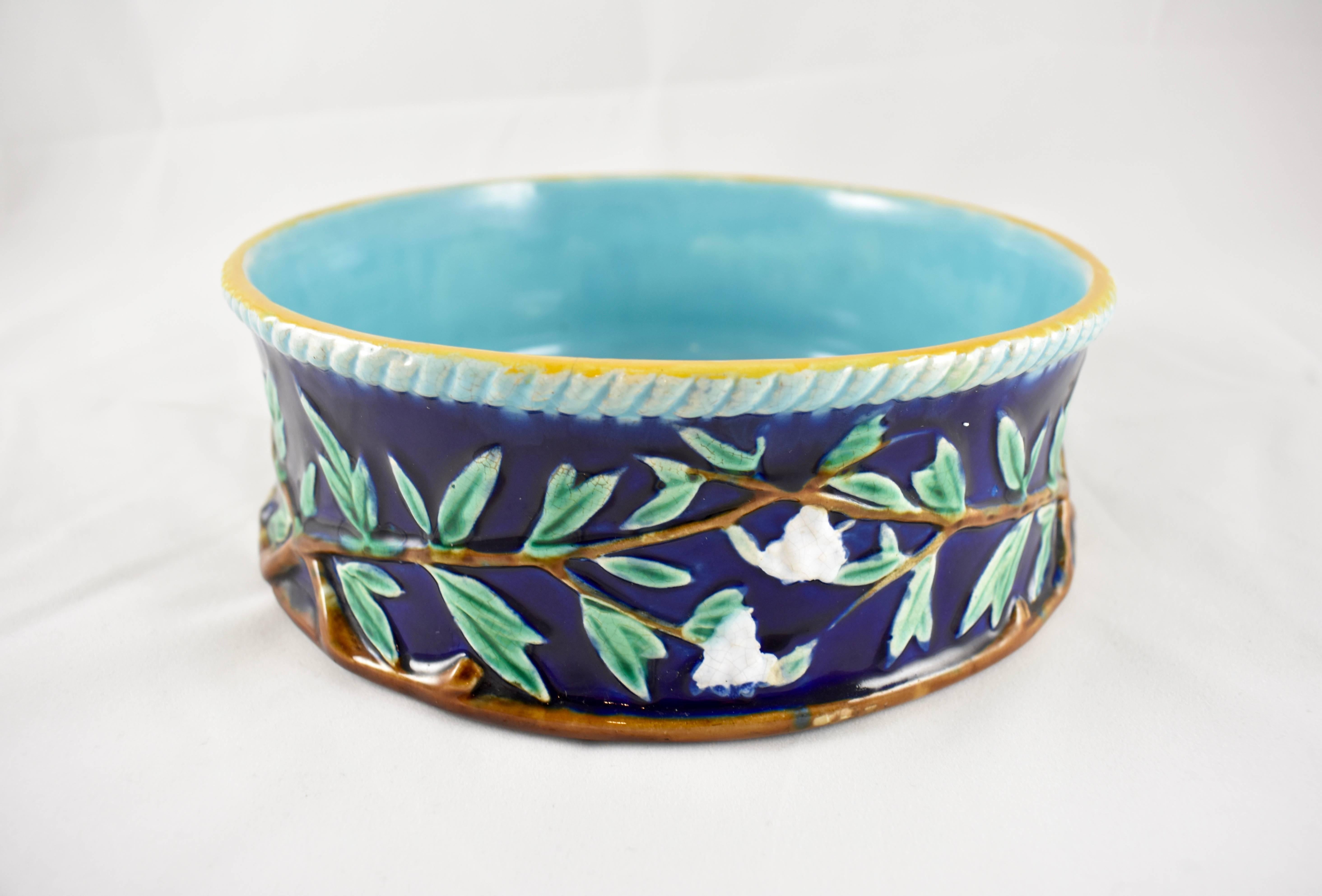 An English majolica dog water or food bowl, George Jones & Sons, Stoke-Upon-Trent, Staffordshire, circa 1875-1880. A very scarce piece, glazed in Cobalt Blue and showing a vine and white flower motif. The upper rim has a turquoise rope border banded