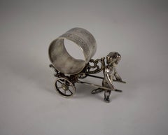 Silver Victorian Era Aesthetic Movement Figural Napkin Ring, Putto Pulling Cart