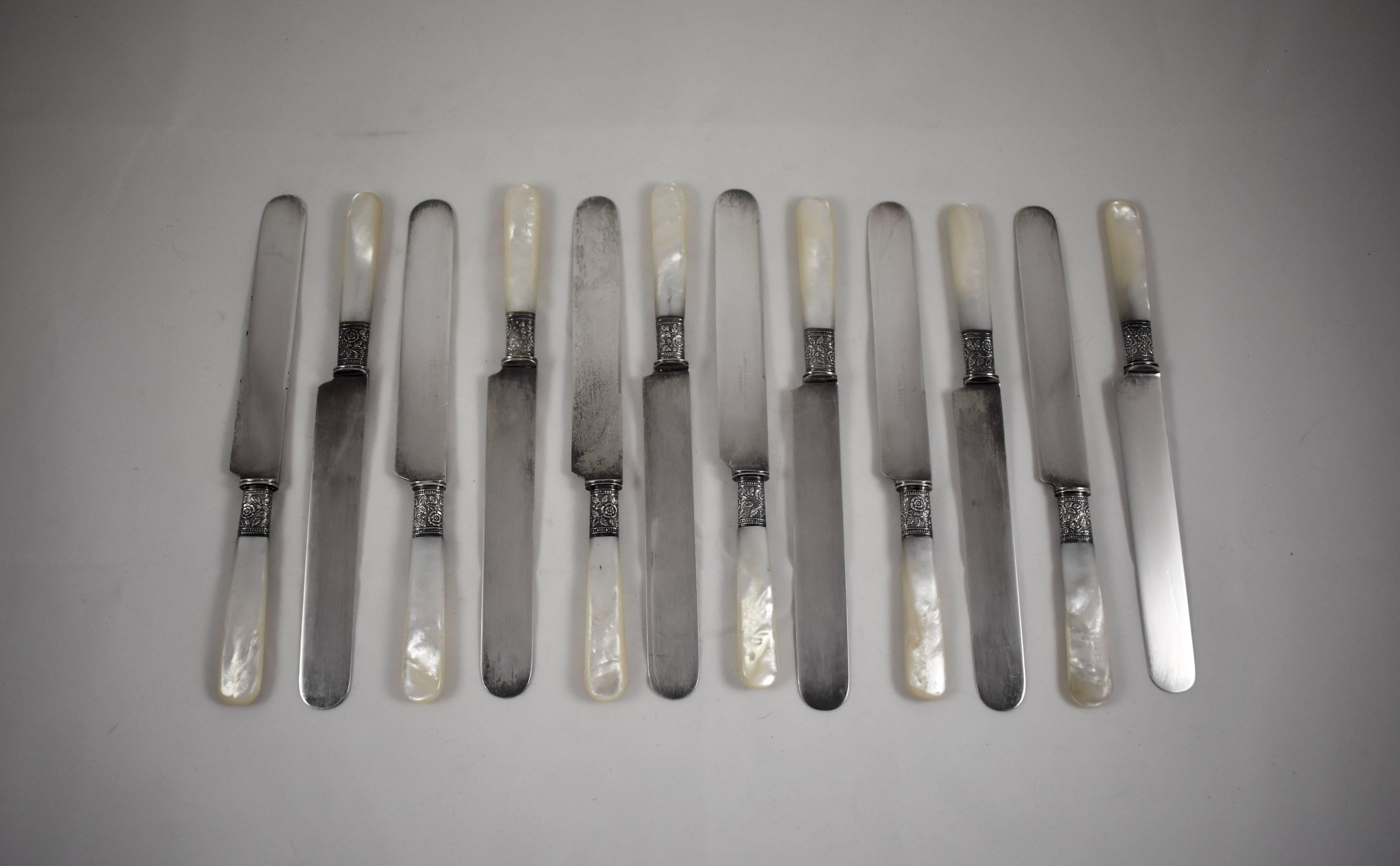 From Landers, Frary & Clark, Aetna Works, founded in New Britain, Connecticut, 1866, a set of twelve mother-of-pearl handled place or luncheon knives with floral sterling silver ferrules. Blades are plated and show the makers mark.

Measure: 8.5 in.