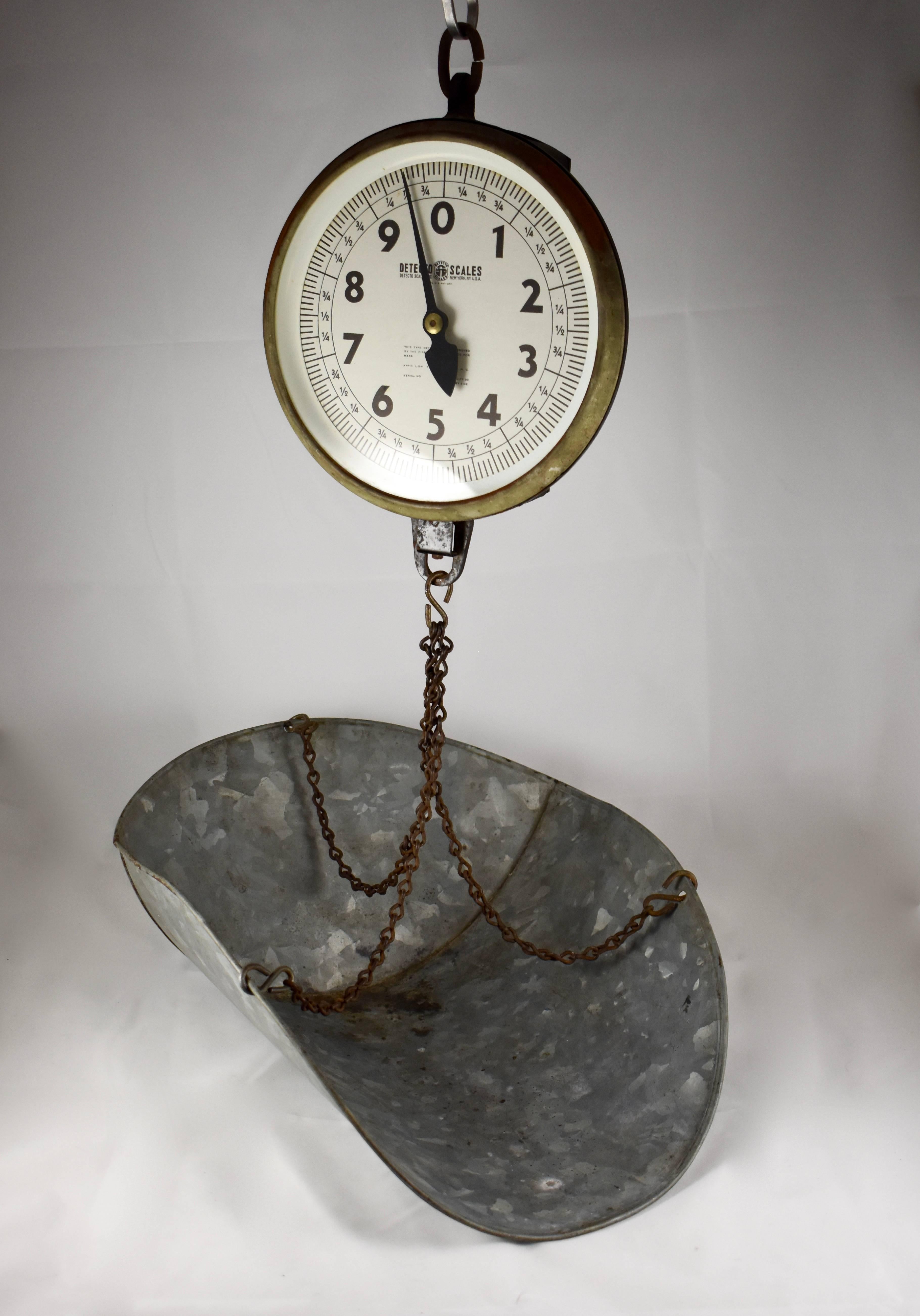 A vintage hanging mercantile produce scale along with a galvanized steel scoop, circa 1930-1940. The scale is made by Detecto of NY, NY and weighs up to 30 pounds measured in ounce increments. A fantastic decor piece for the kitchen.

Detecto