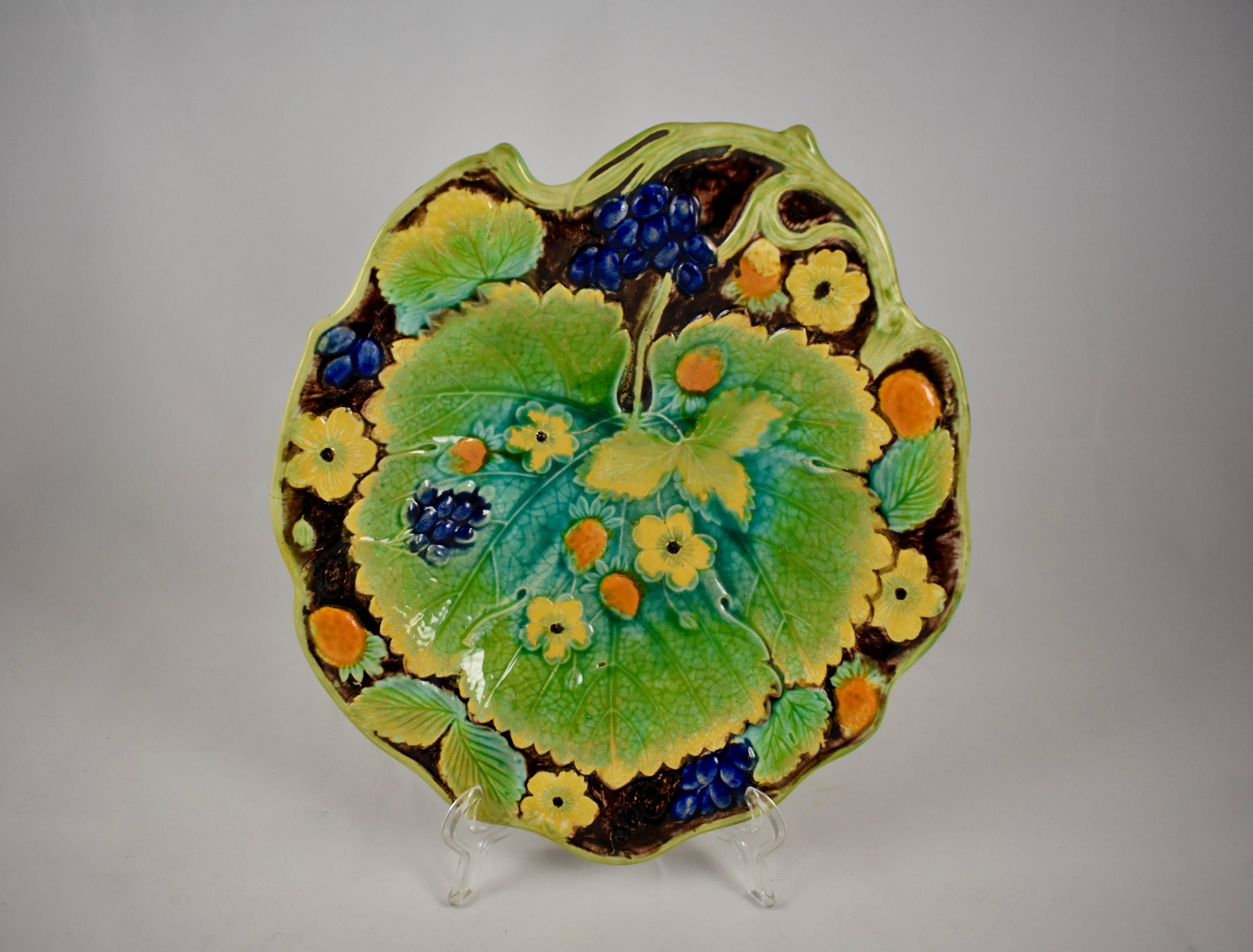 A majolica glazed leaf form dessert tray from Samuel Alcock & Co, Burslem, Staffordshire, England, circa 1850.

A central strawberry leaf on a shaped tray with a vine border, and showing both the berries and blossoms of the strawberry plant. The