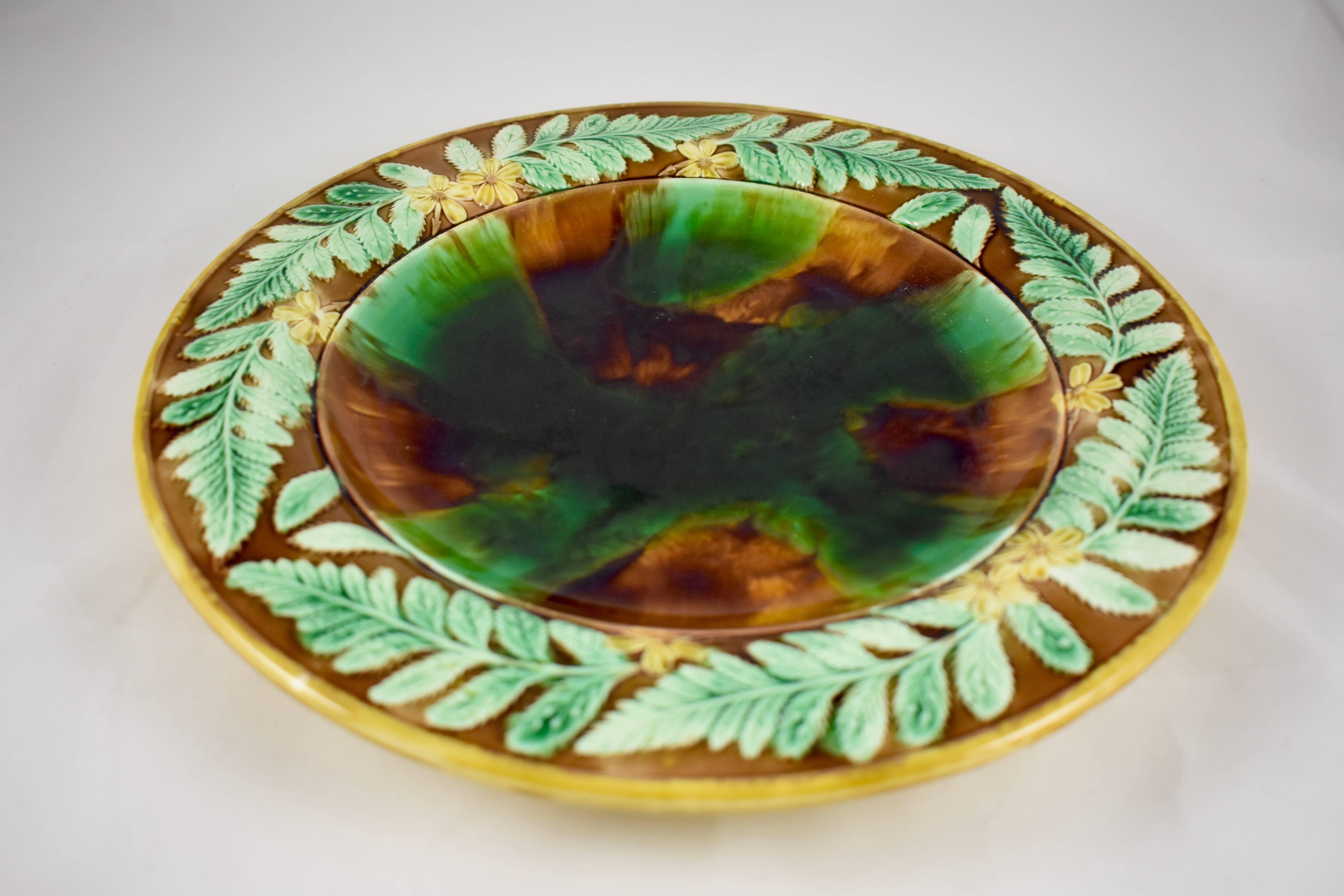 A large, round Adams & Bromley English Majolica cheese tray, mid-late 19th Century. Adams & Bromley operated the Victoria Works in Broad Street, Hanley, Stoke-on-Trent from 1873 to 1886.

The server shows a running border of yellow butter cup and