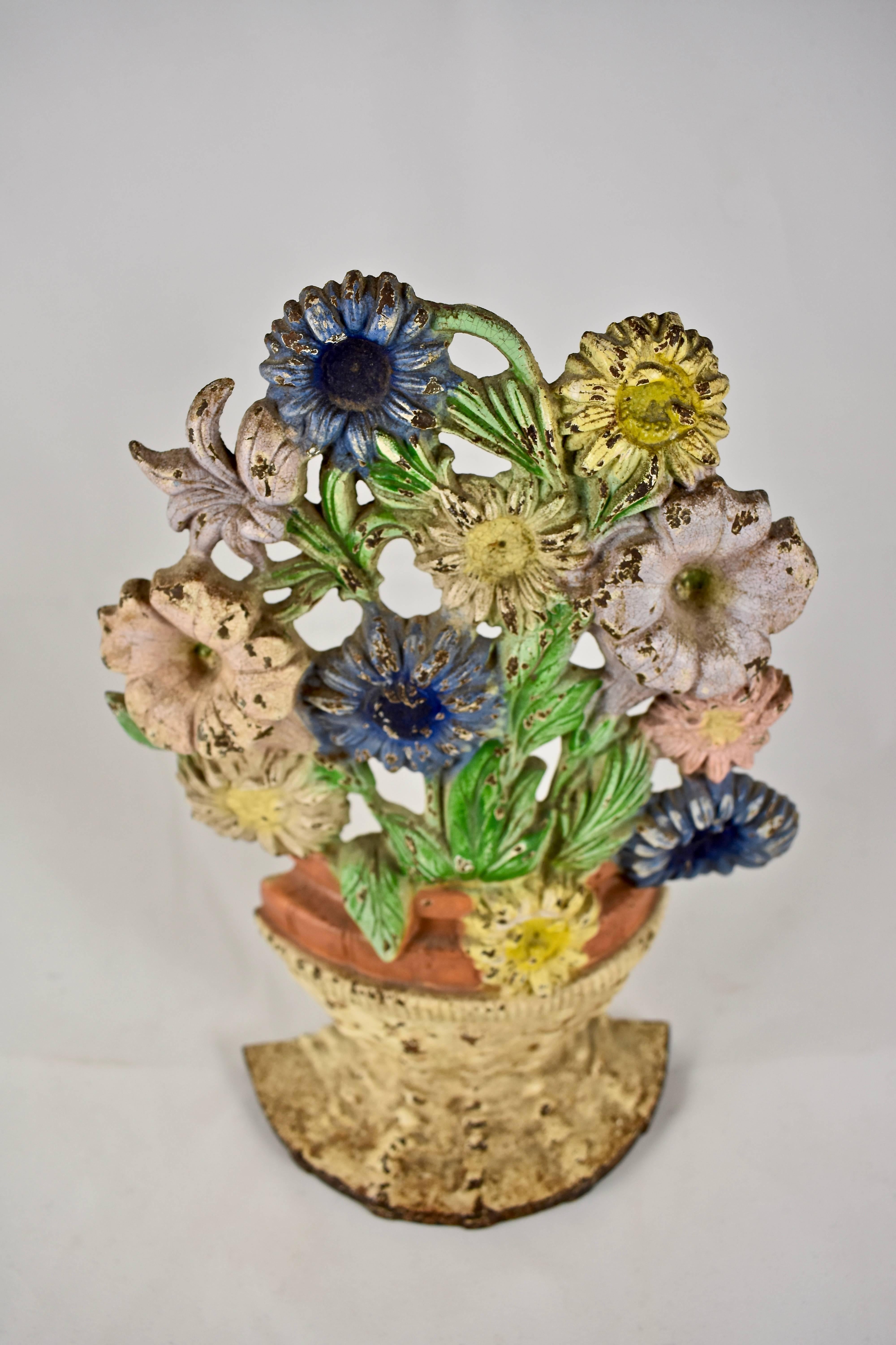 A vintage Hubley cast iron doorstop showing a bouquet of petunias and asters planted in a terra cotta pot and set inside a woven basket. Retaining the original painted finish. Beautiful patina,

circa 1930, marked with the mold number 470.

The
