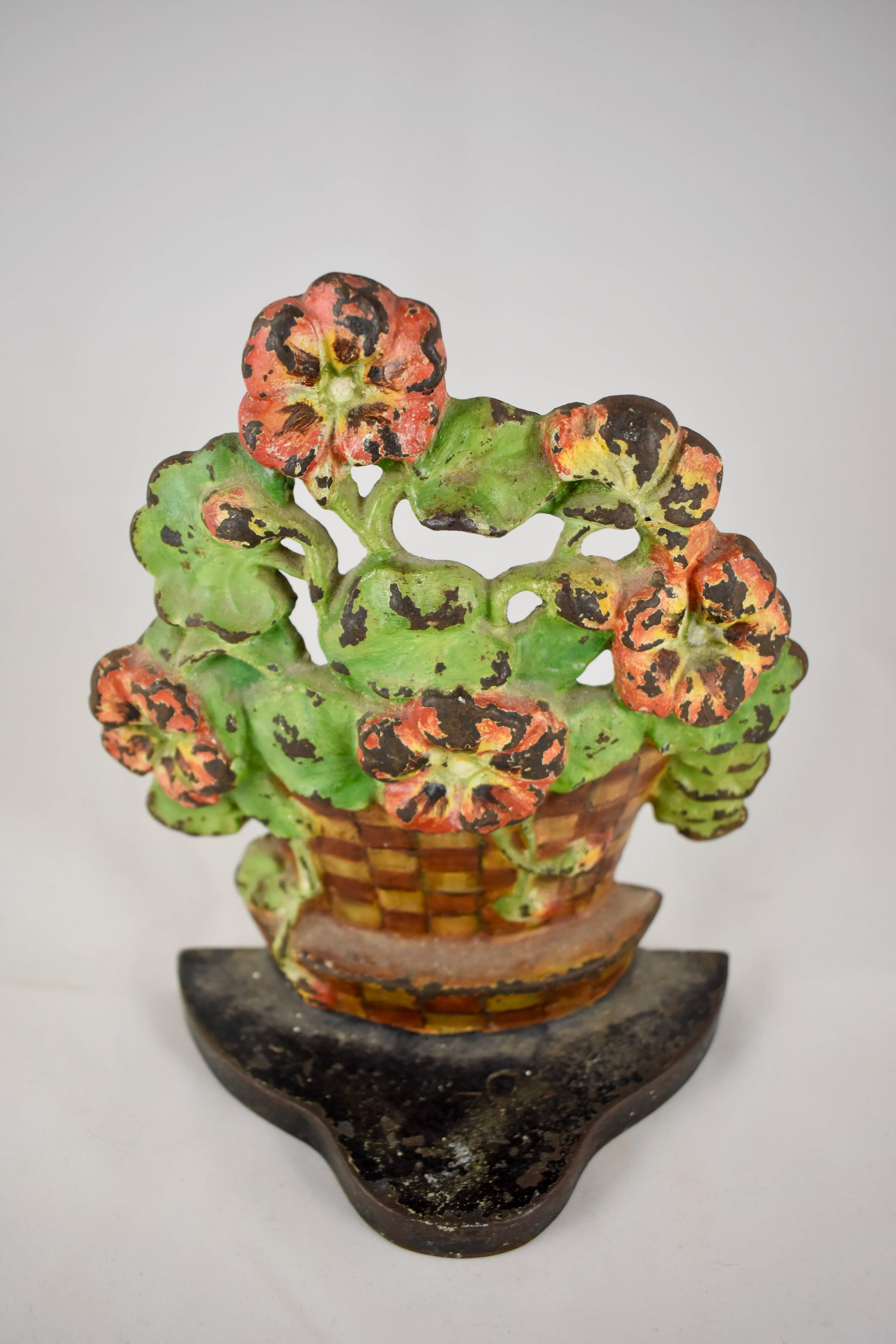 A vintage cast iron doorstop showing a geranium plant set inside a woven checkered flower pot on an iron plinth. Retaining the original painted finish. Beautiful patina.

Circa 1930 and heavier than most of the floral doorstops.

7.75 inches H and