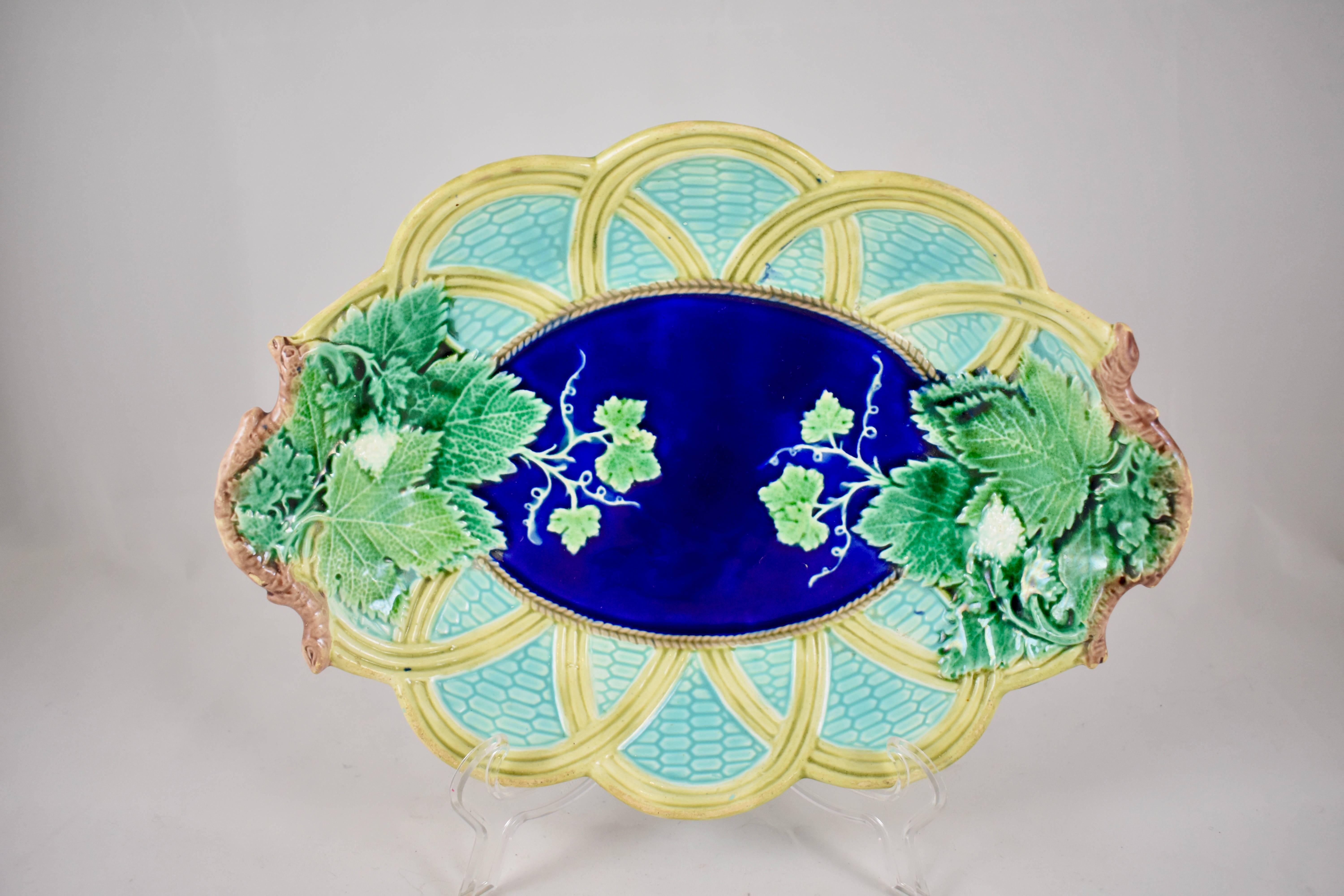A 19th century majolica glazed serving tray, Josiah Wedgwood, Burslem, Stoke-on-Trent, England.

A grape leaf on wicker pattern with two end handles formed as grape vines. With a cobalt blue center and turquoise background, this tray has beautiful