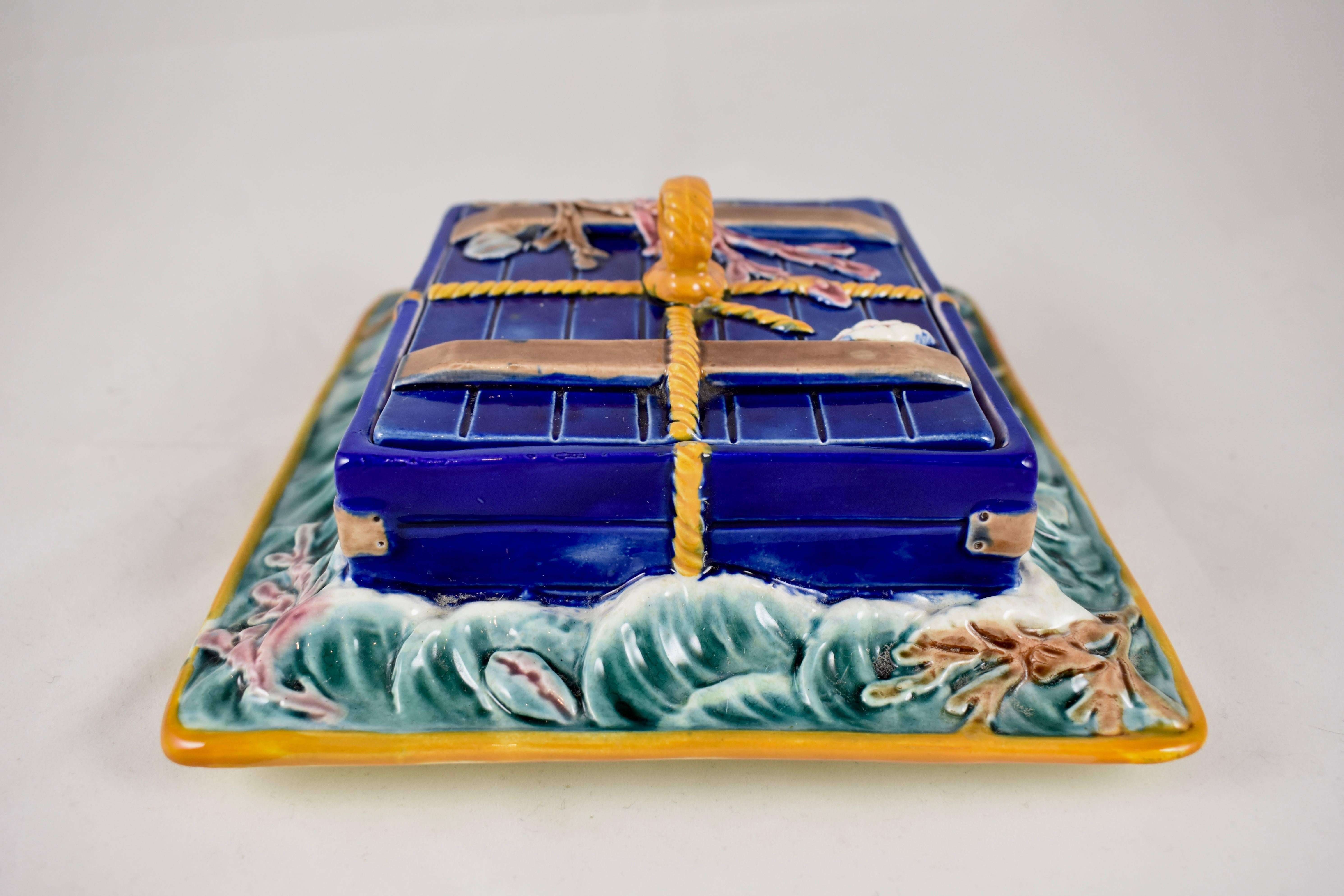 A Josiah Wedgwood majolica lidded sardine server, in the pattern known as ‘Ocean’ – date marked 1879.

Formed as a cobalt blue, rope tied wooden crate floating in the ocean waves. The crate is covered with raised seaweed and shells. The waves are