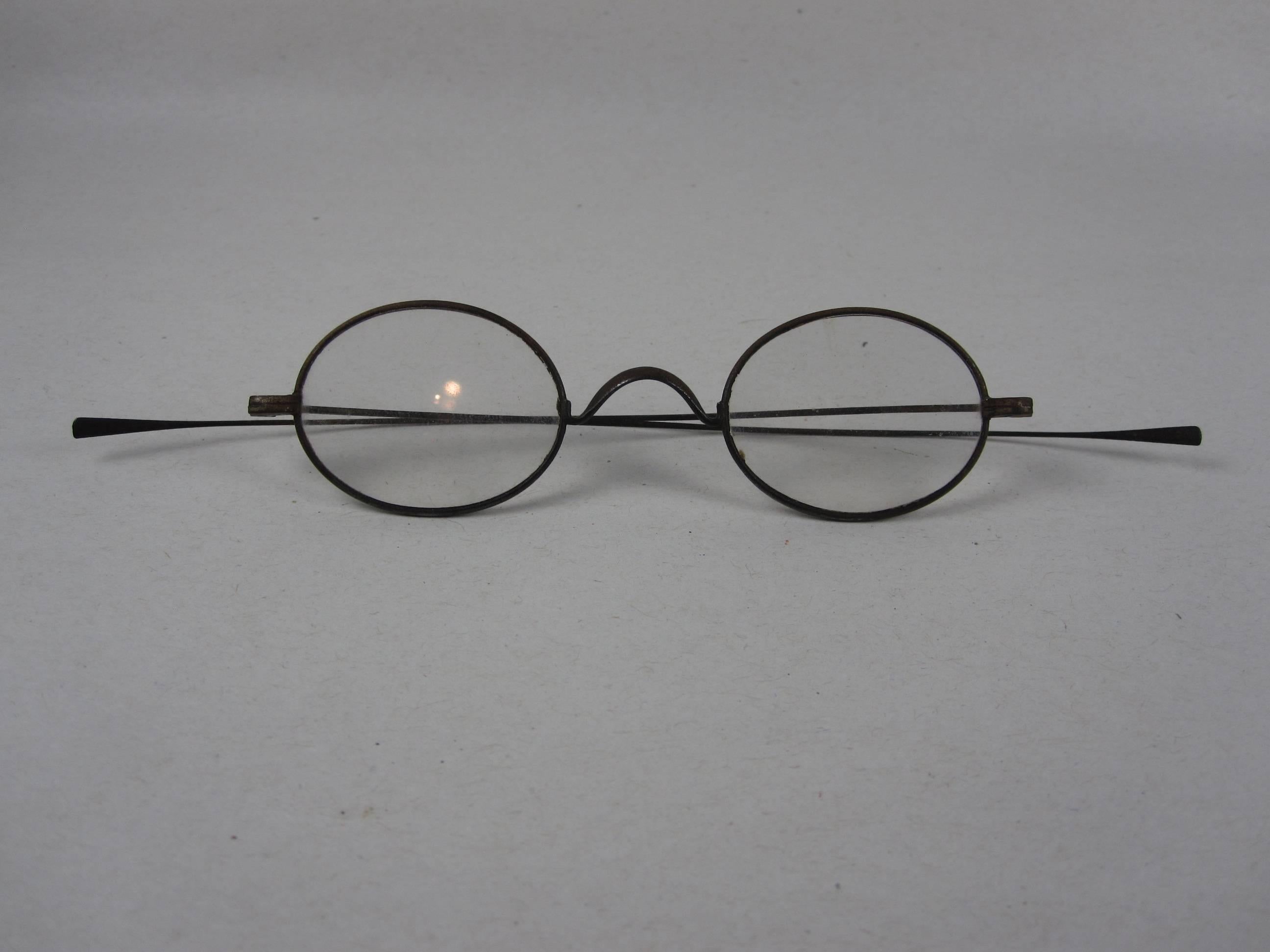 A delicate pair of handmade magnifying wire rim eye glasses from the American Civil War era, circa 1860. 

A great looking historical conversation piece or decor item. Use this pair to accessorize a desk, placed on an open book in a home library, or